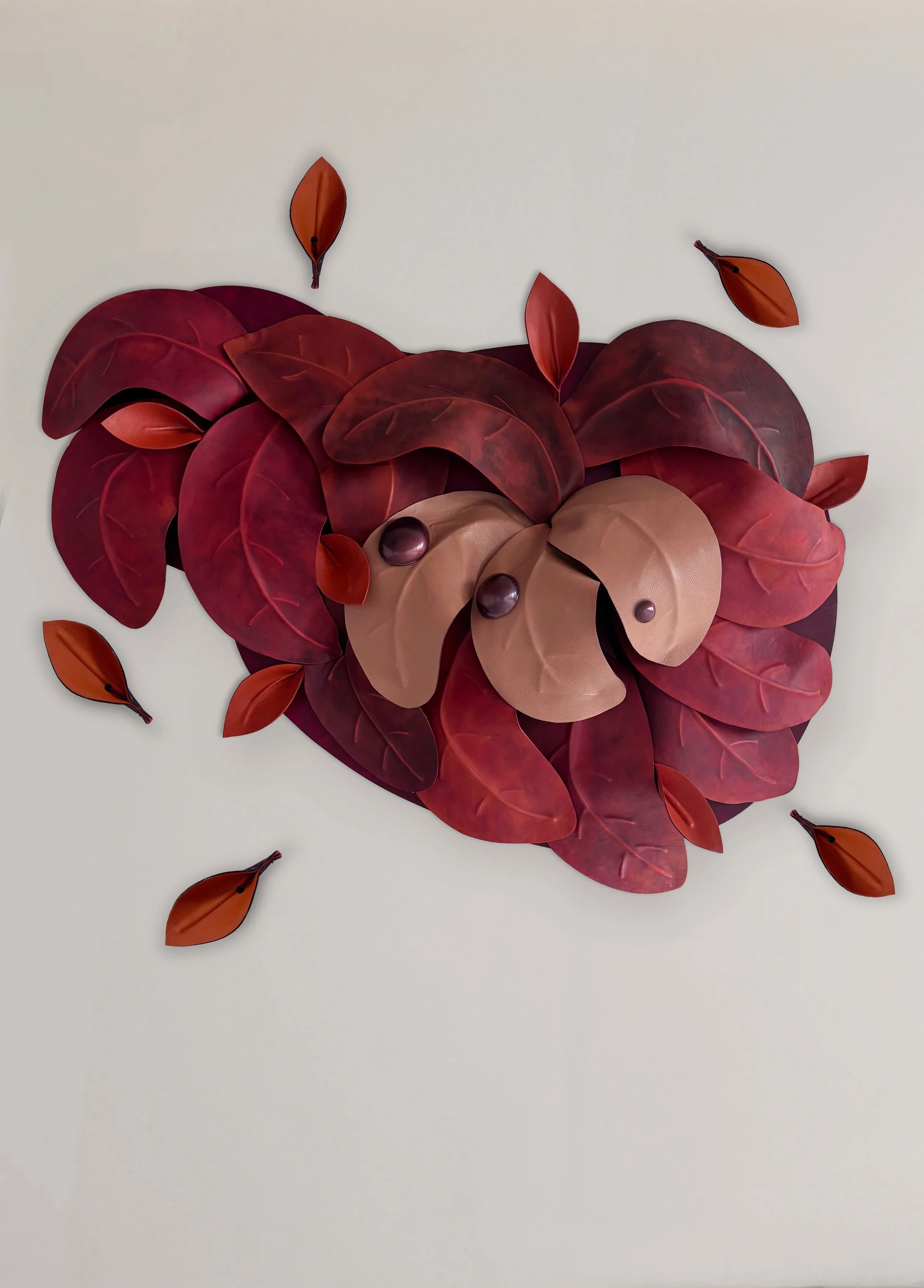 Madelon Uljee’s After the Storm, a sculptural wall installation of burgundy and orange leather leaves.
