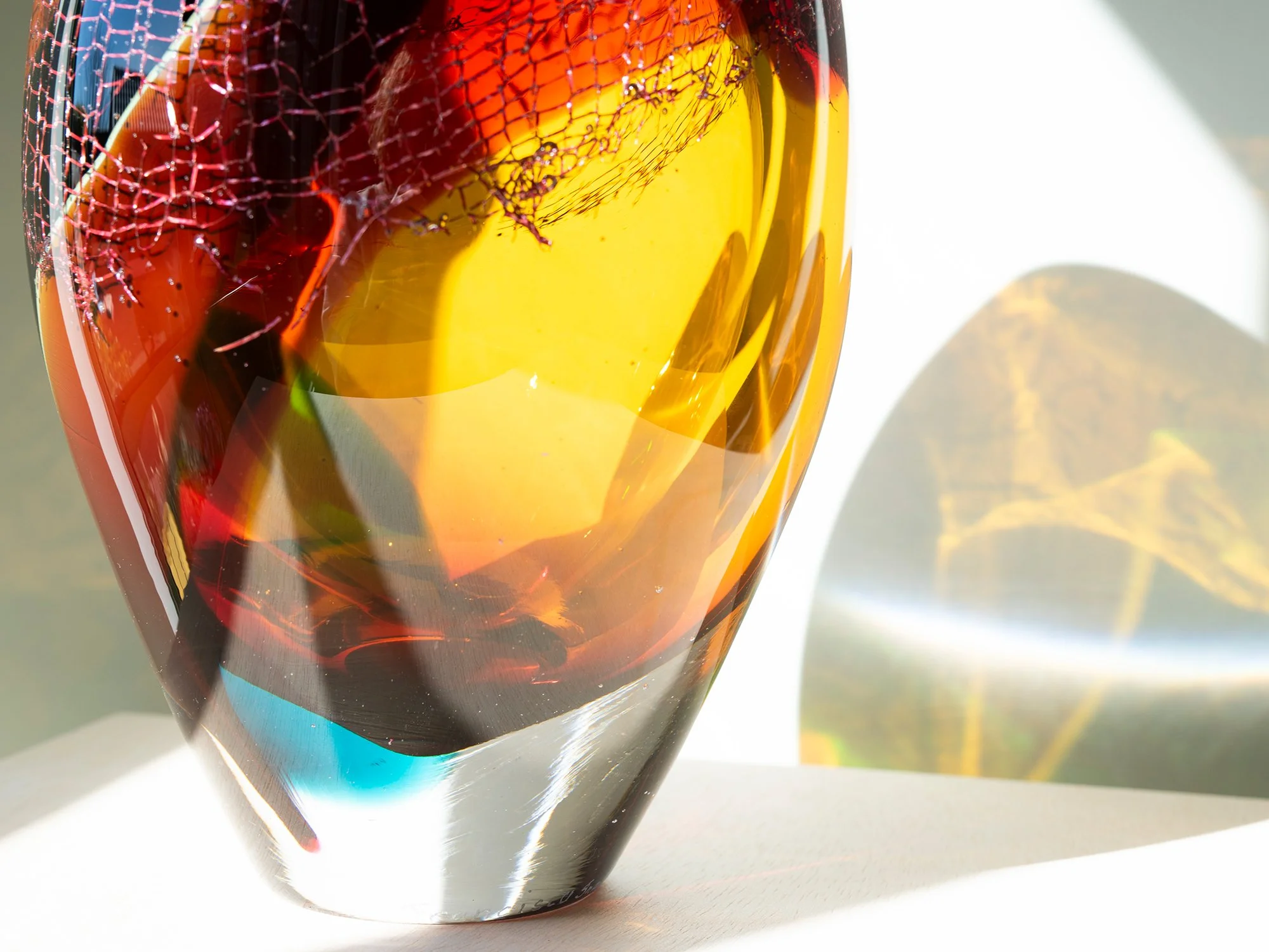 Close-up of copper mesh embedded within coloured blown glass in a sculpture by Francisca Snel