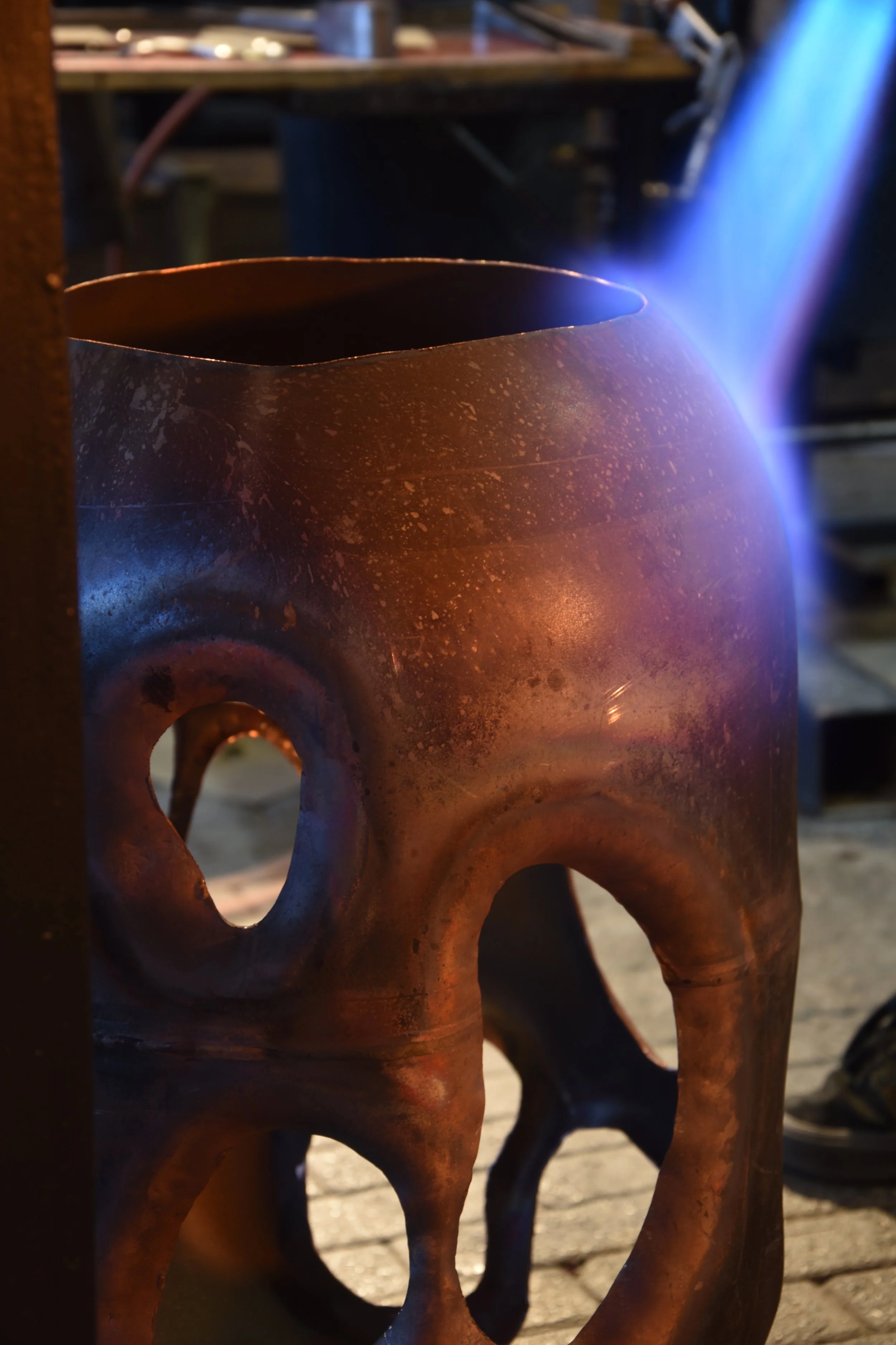 Copper sculpture by Anna Oudhof during production in the workshop, showing the organic cut openings in the metal surface.