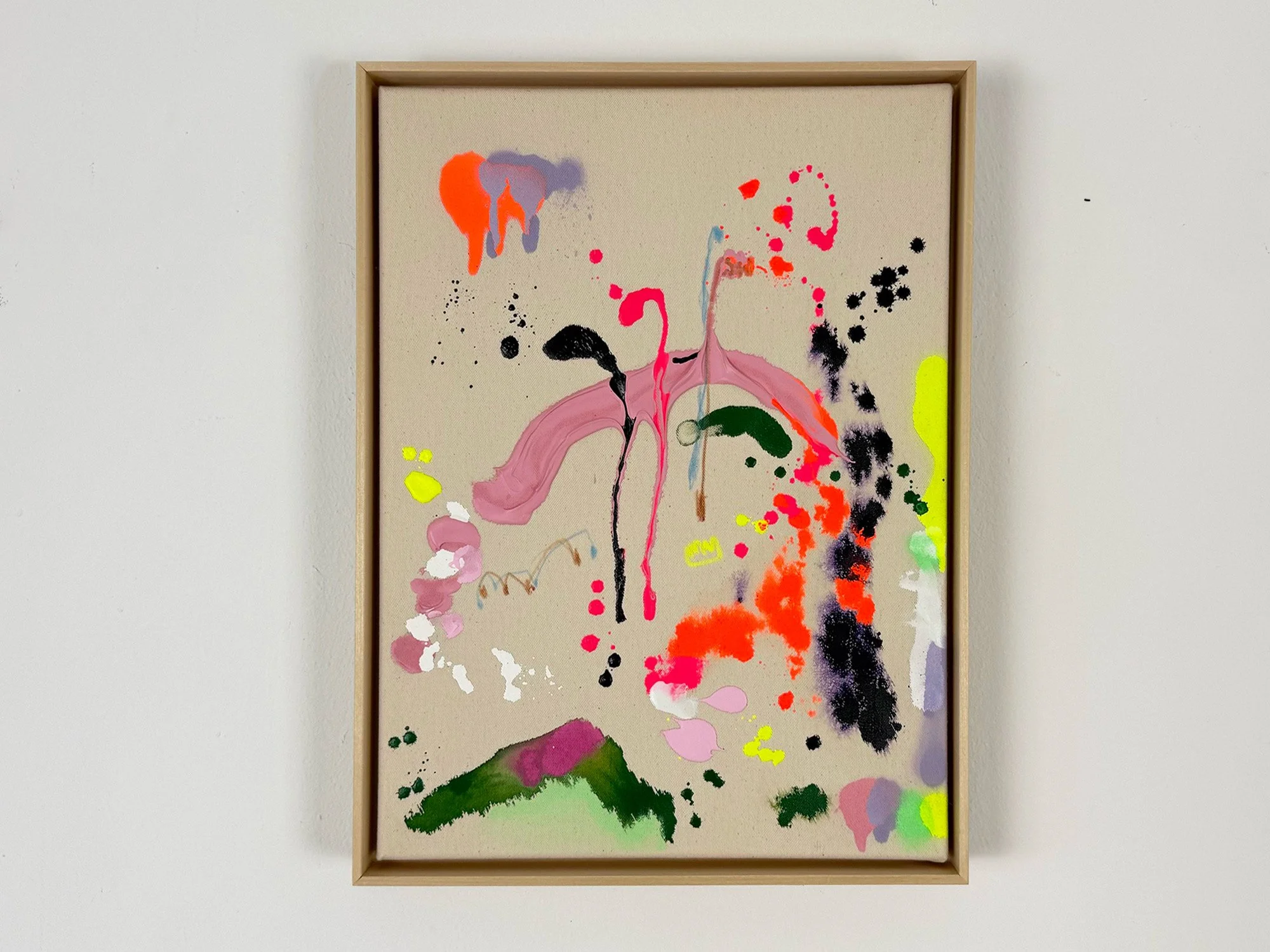 Abstract mixed media painting by Vera Klaus with bright pink, orange and green paint marks on raw canvas, shown in a wooden frame on a white wall.