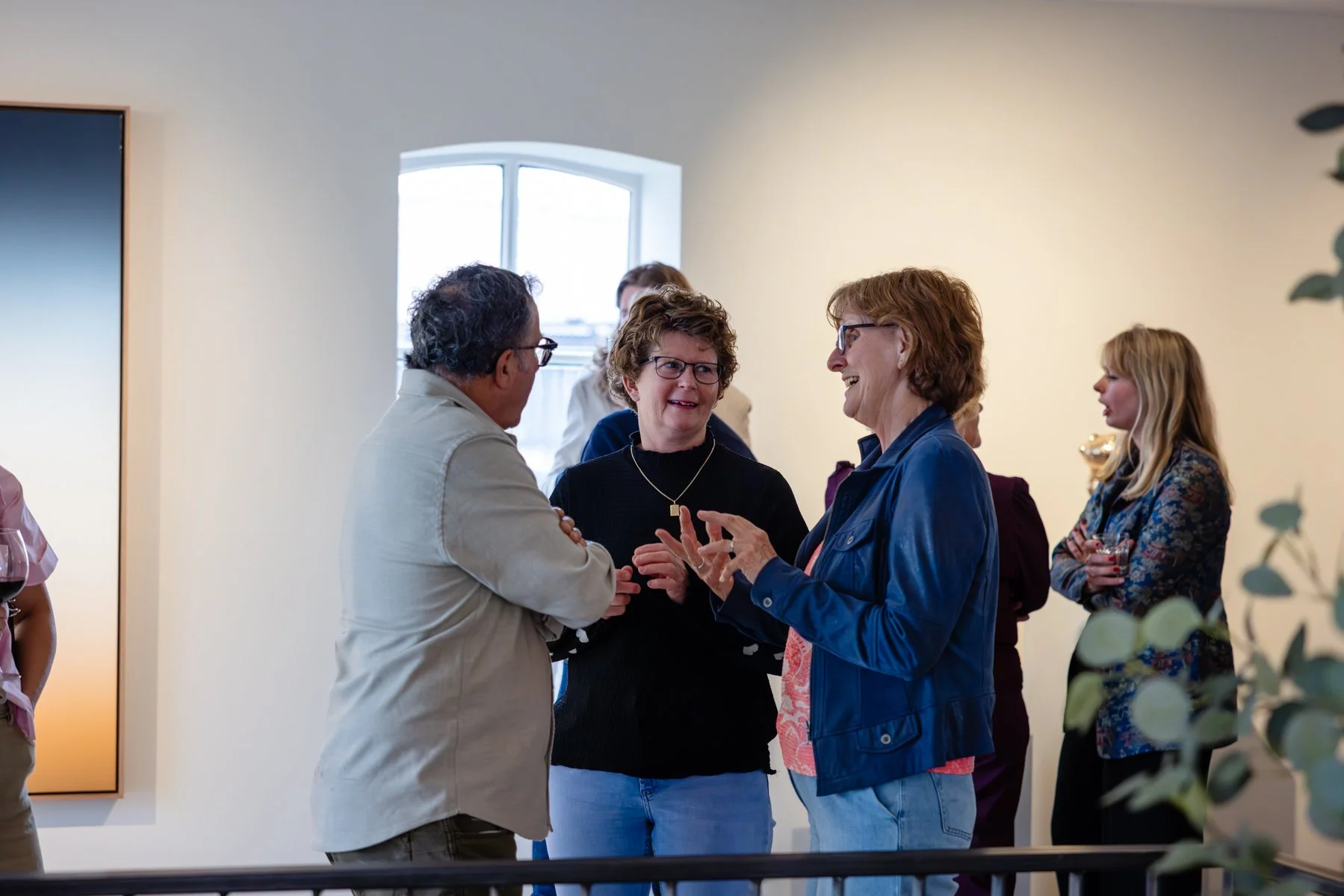 People gathering and talking in a gallery setting during a private event near Rotterdam