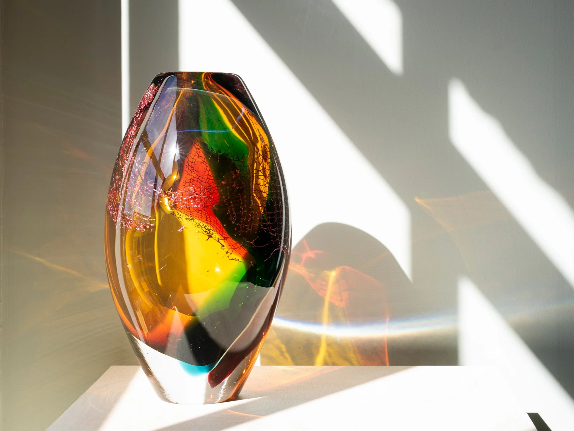 Side view of Francisca Snel glass sculpture with red, green and yellow glass