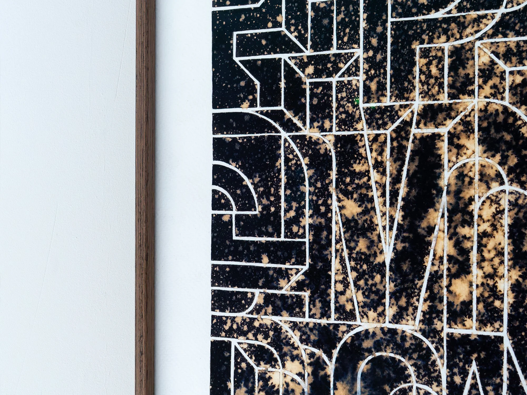Close-up along the wooden frame and lower letterforms of Ephemeral, showing the contrast between the dark ground and bleached marks.