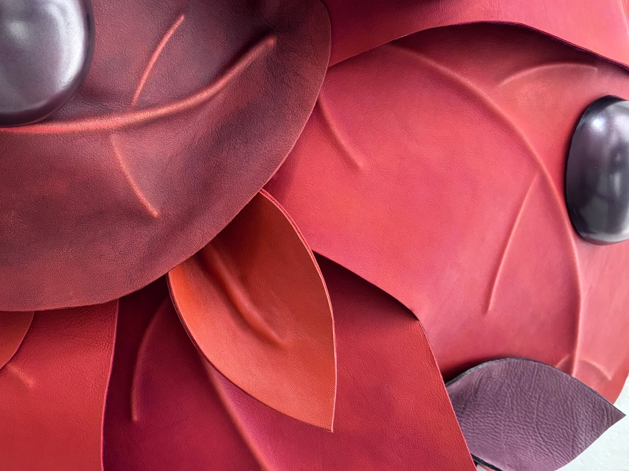 Detail of After the Storm by Madelon Uljee, showing leaf veins, leather textures and a dark glossy droplet.