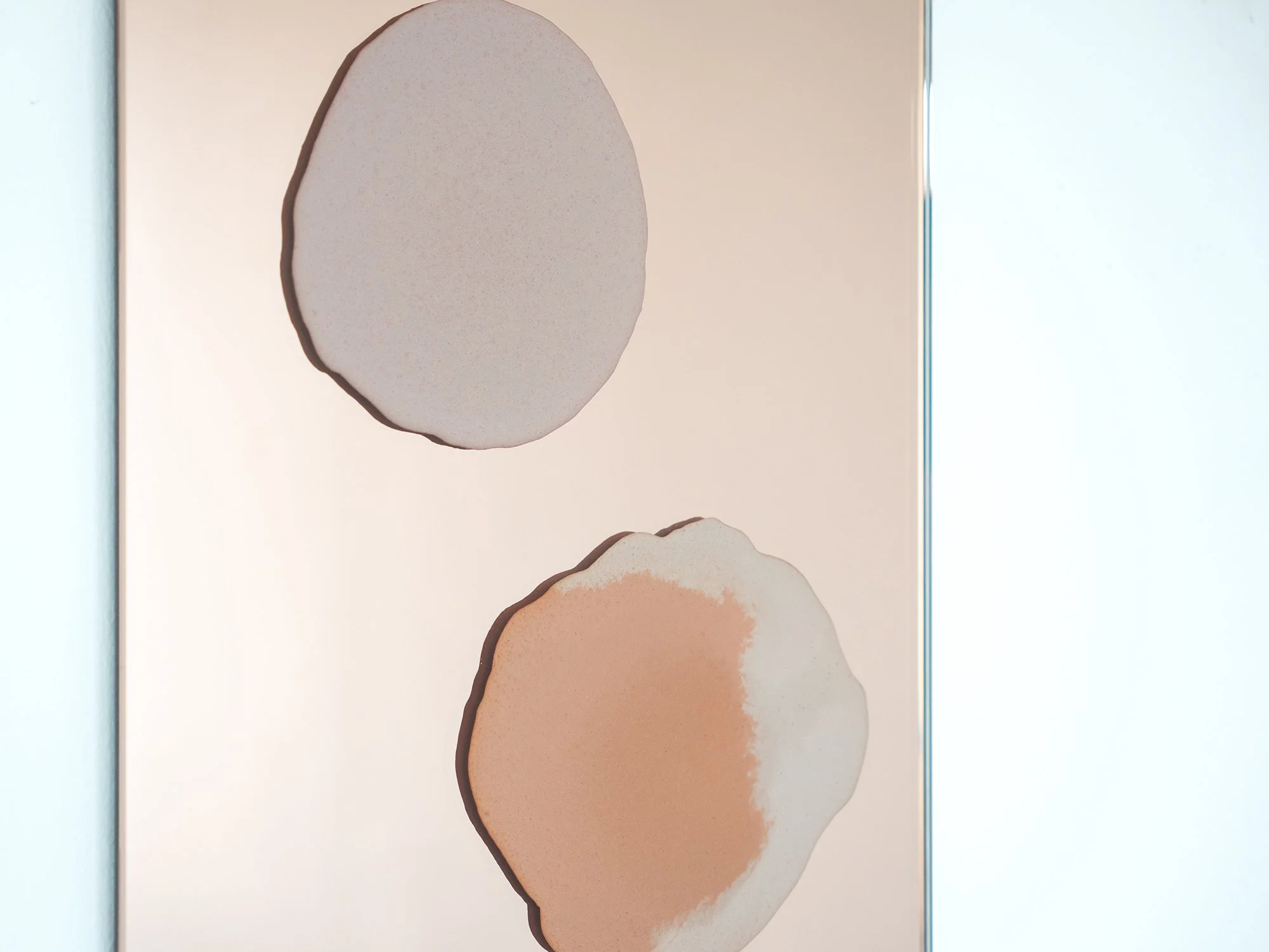Angled view of Quinda Verheul’s Moroccan desert-inspired wall sculpture in rose mirror and mixed concrete