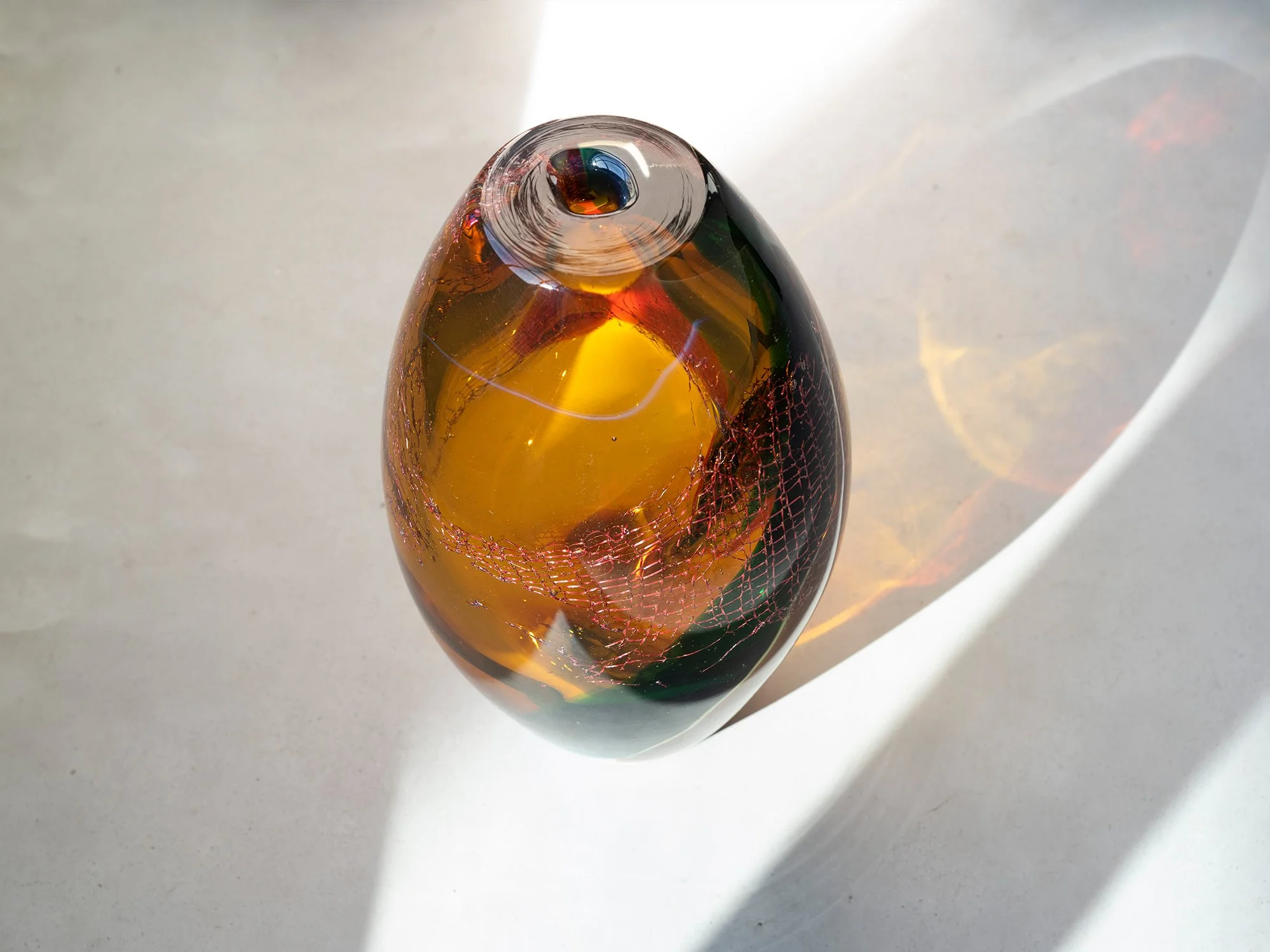 Glass sculpture by Francisca Snel seen from above with red, green and amber colour layers