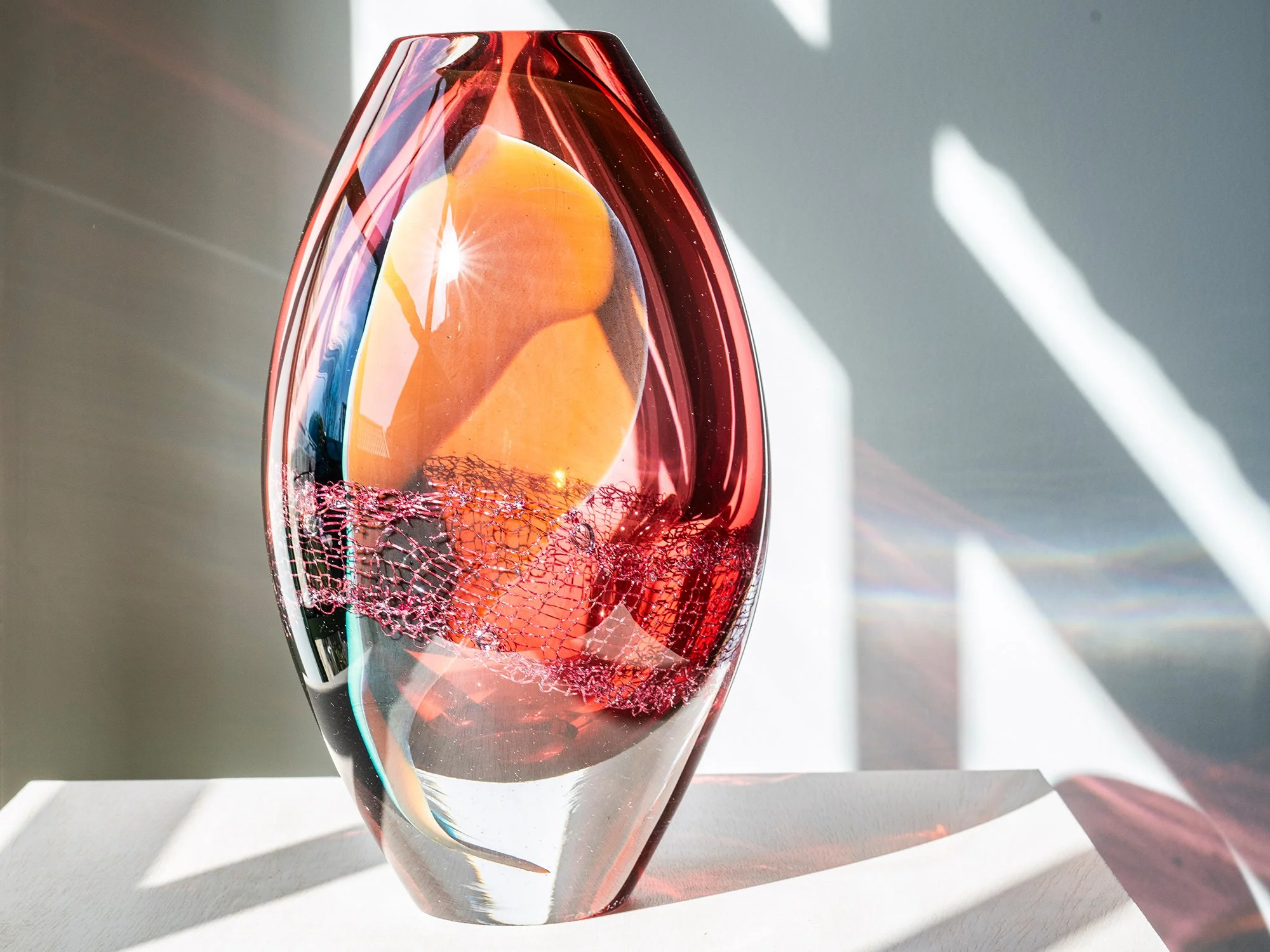 Contemporary glass sculpture by Francisca Snel with warm orange, amber and red layers