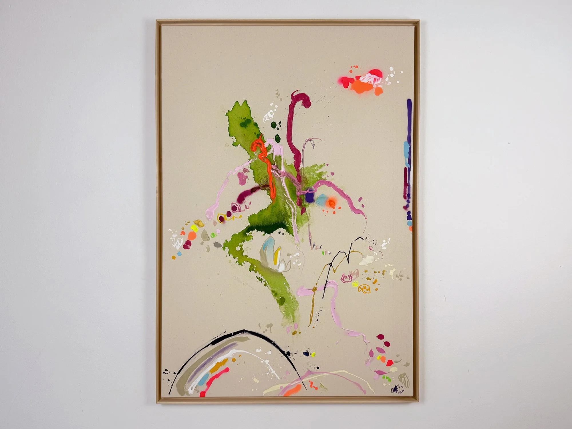 Abstract painting Entdeckung am Wiesenrand by Vera Klaus hanging on a white wall, 120 × 80 cm. The canvas shows vibrant green, pink, and orange gestures on a raw linen background.