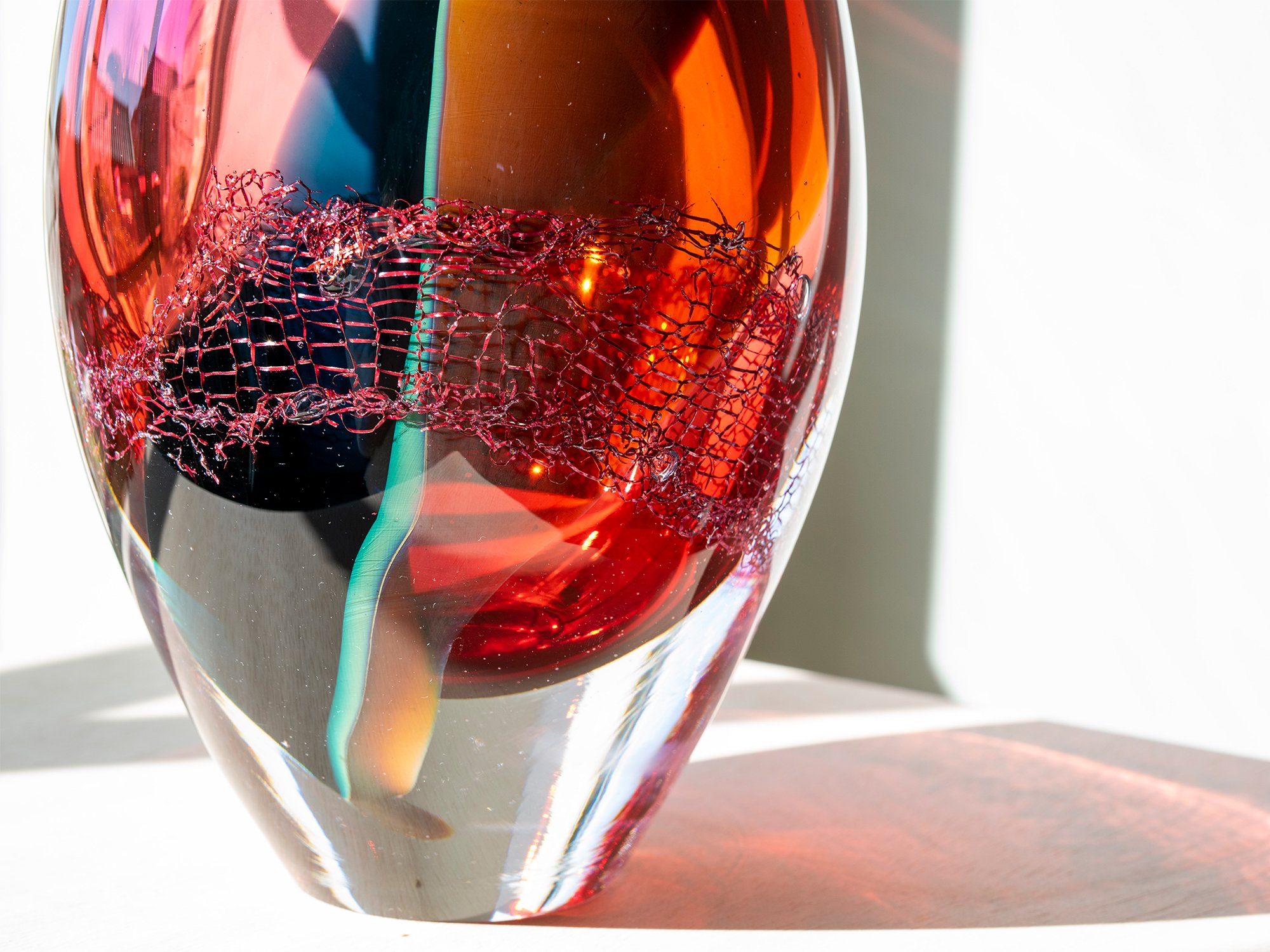 Close-up of copper cleaning sponge embedded in warm coloured glass by Francisca Snel