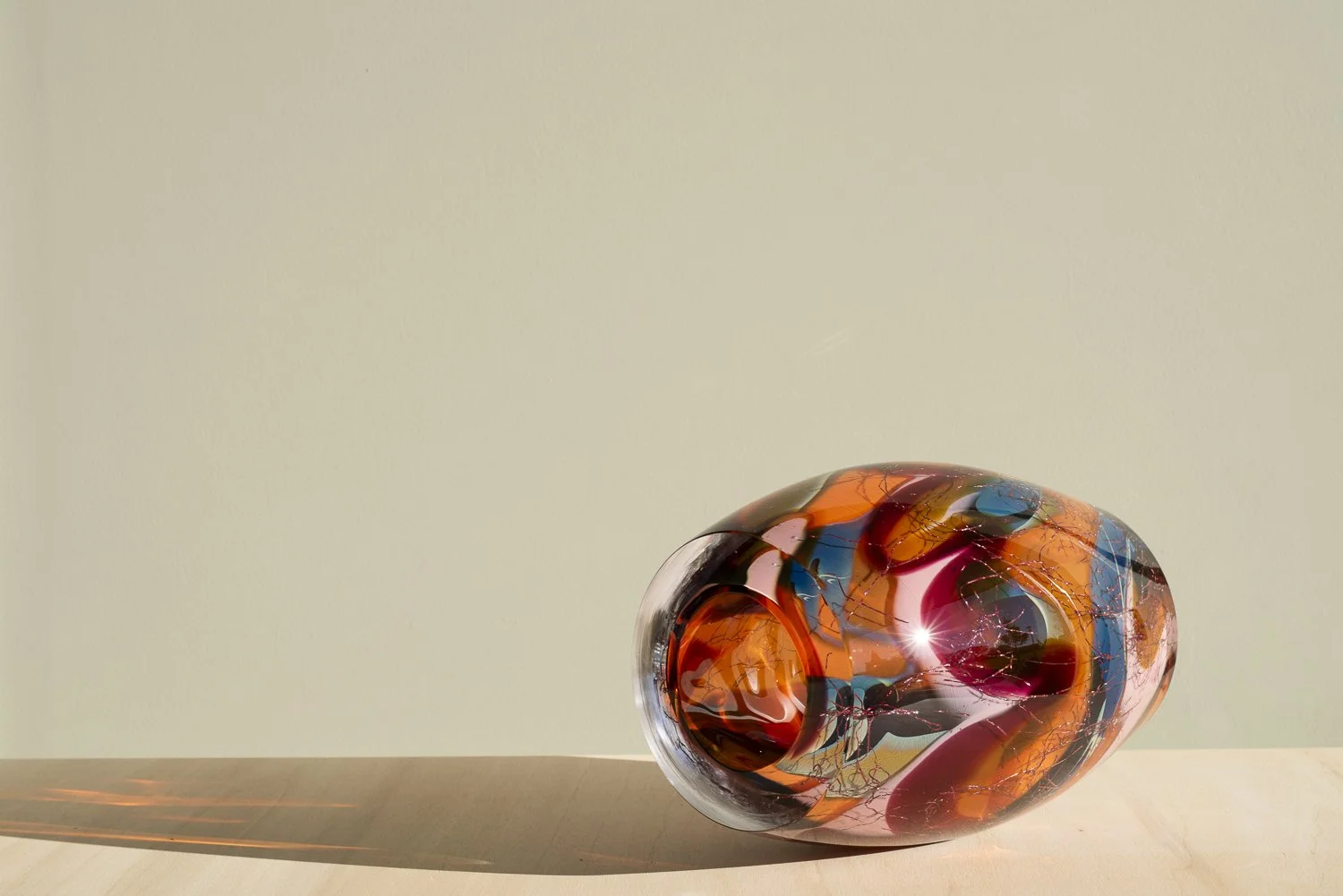 Angled end view of Stellar Magnitude 4, with light passing through its orange glass opening.