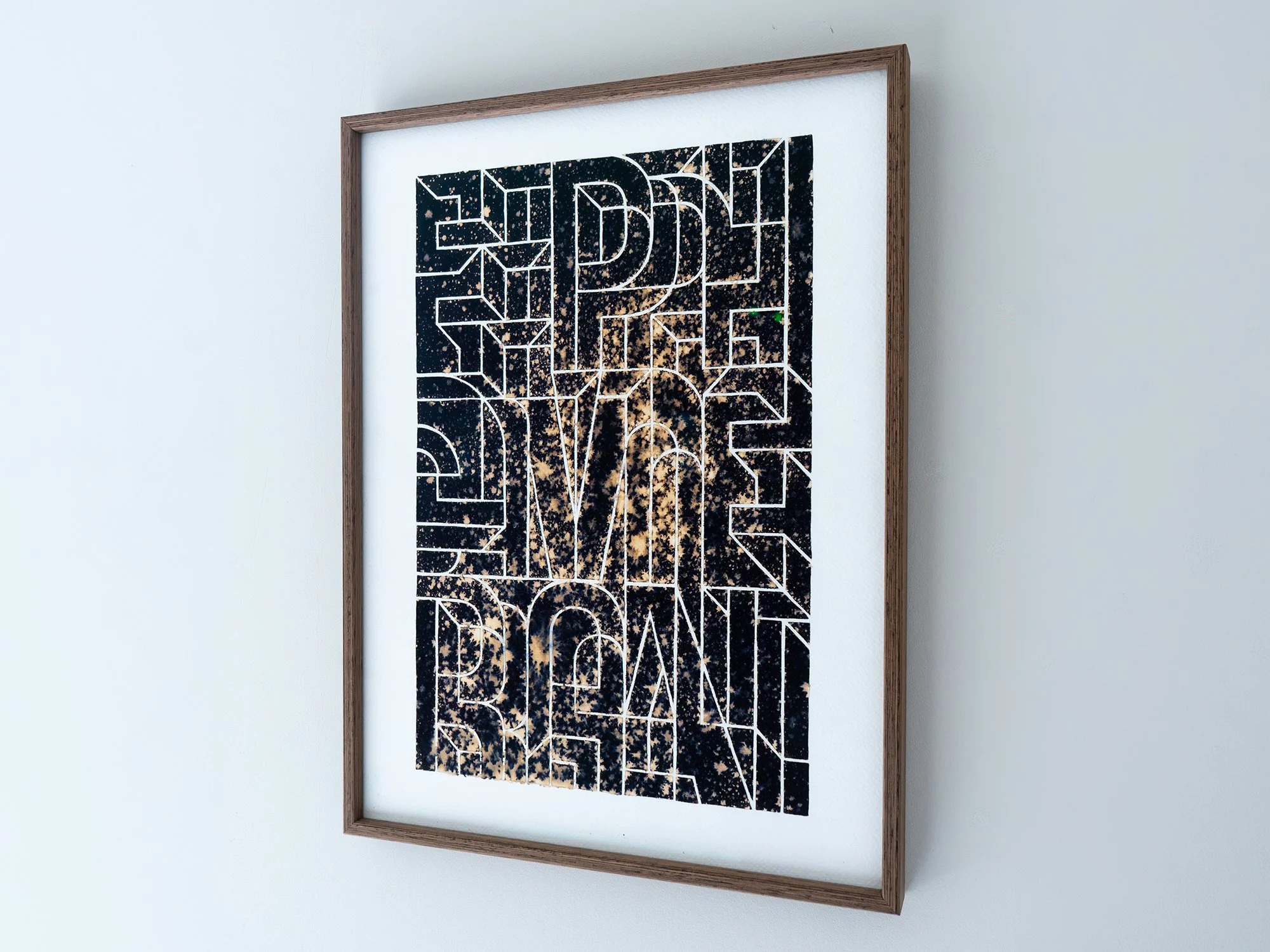 Angled view of Saïd Kinos’s Ephemeral, with outlined letterforms across a dark, irregularly bleached surface.