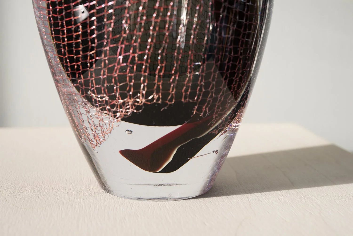 Detail of near-black, deep red and turquoise glass layers in a contemporary sculpture by Francisca Snel.