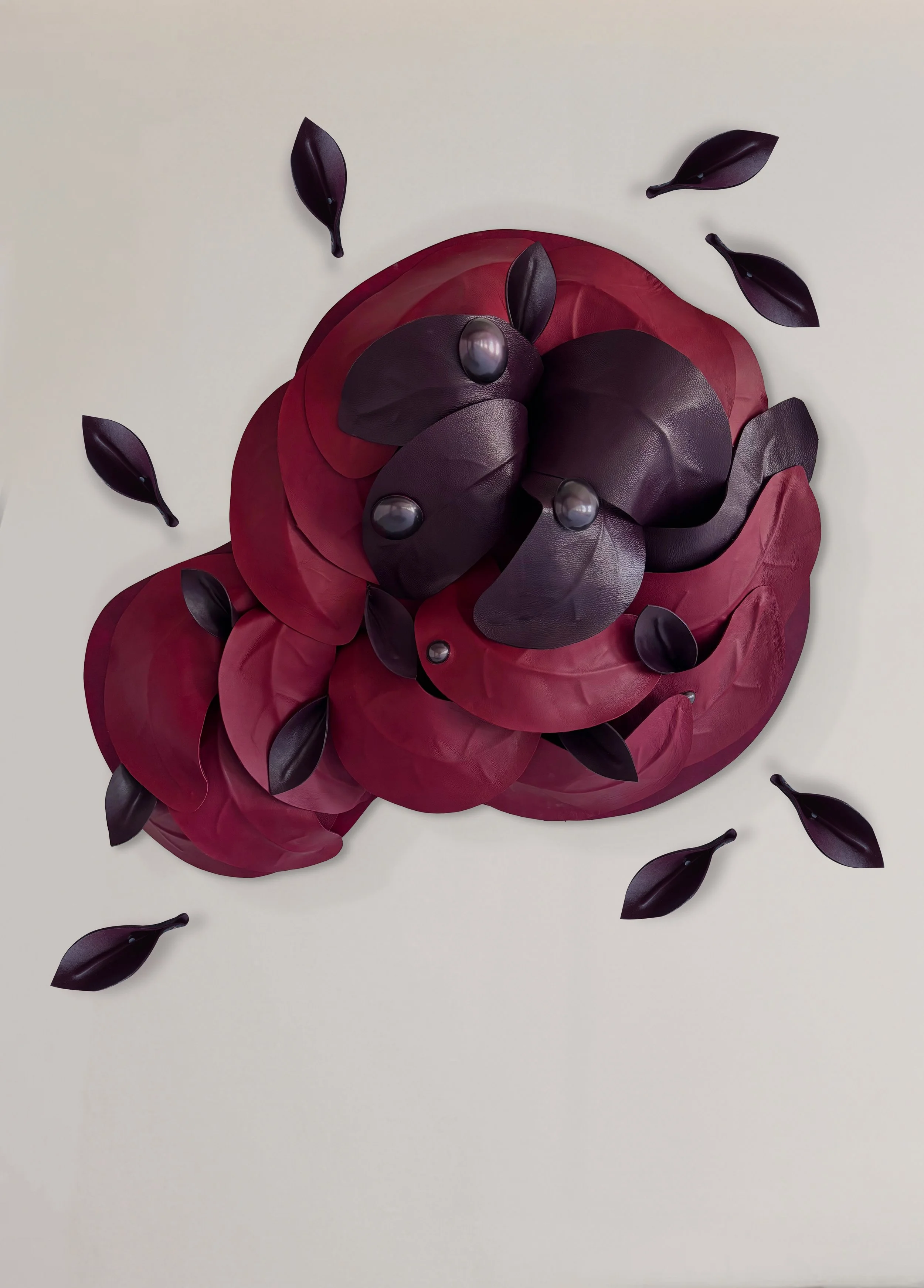 Red and aubergine leather wall sculpture with floating leaves from Madelon Uljee’s After the Storm.
