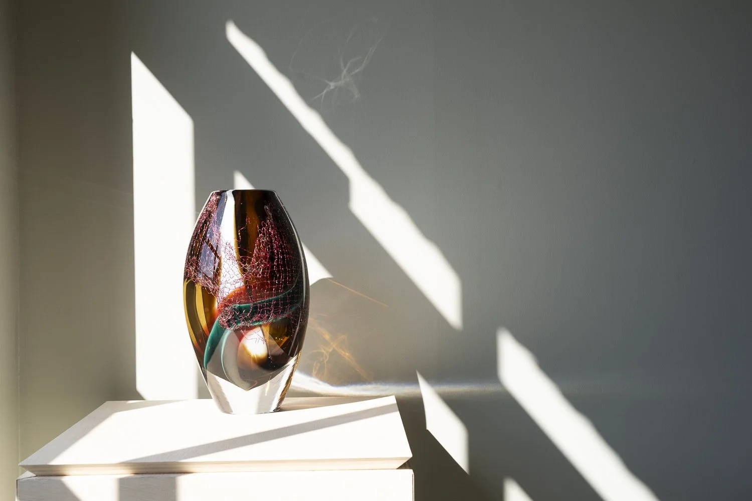 Crystal Clear #14 by Francisca Snel in sunlight, illuminating the copper mesh and coloured glass near the base.