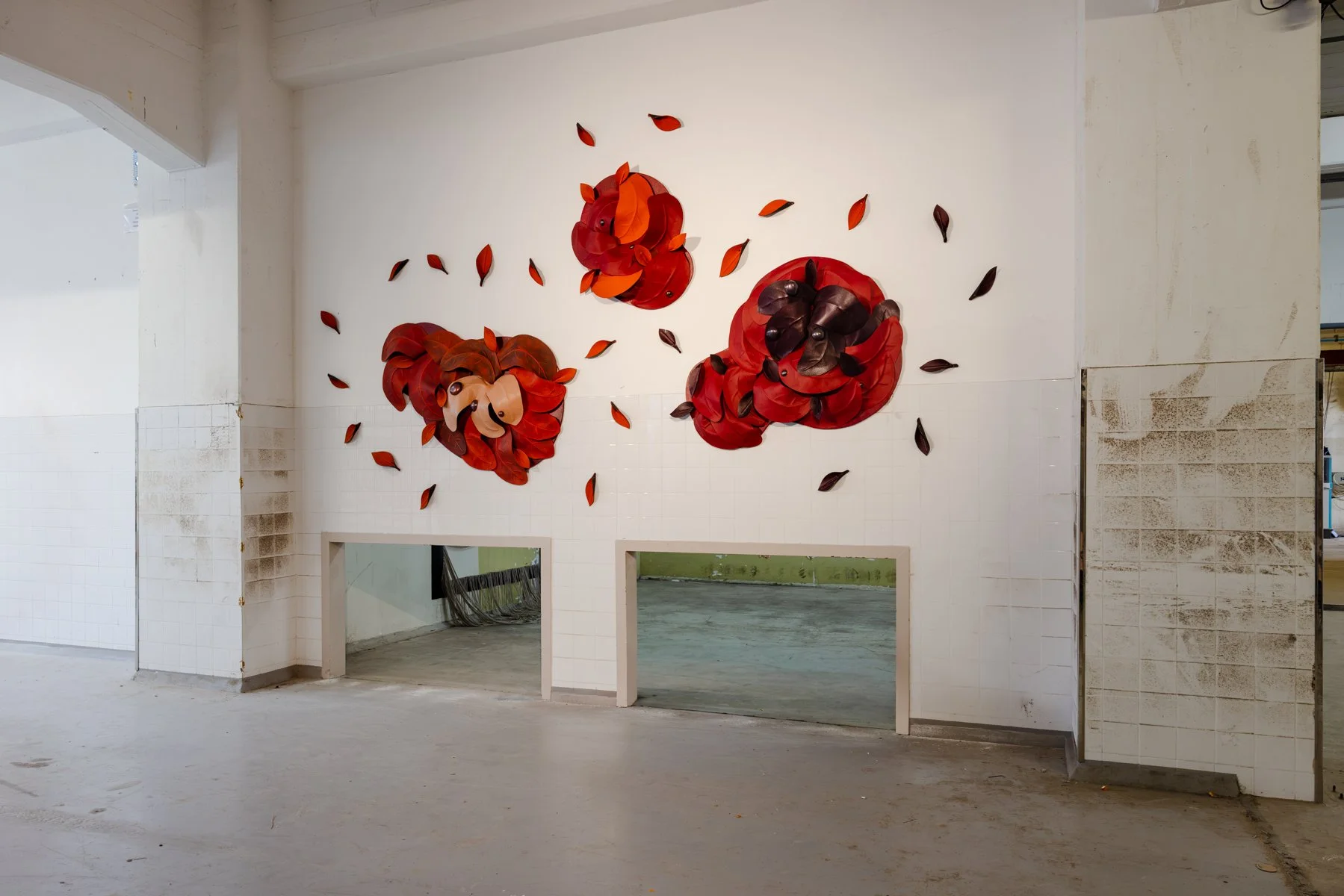 Madelon Uljee’s After the Storm seen from another position in the space, showing the layered construction of the leather wall sculptures.