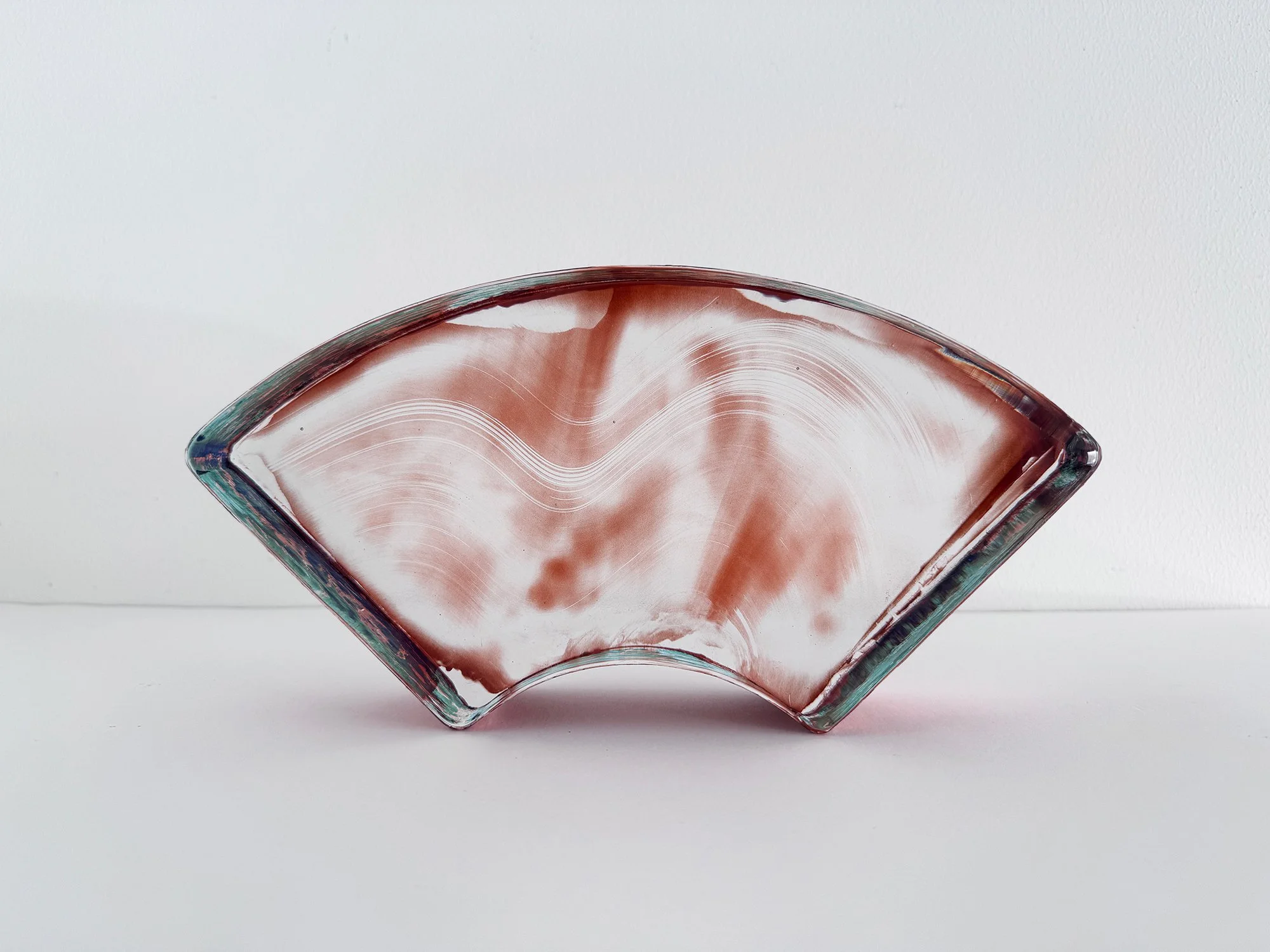 Spatial Shade Segment II by Lisette Schumacher, a fan-shaped pink glass sculpture with flowing white lines and green-tinted edges.