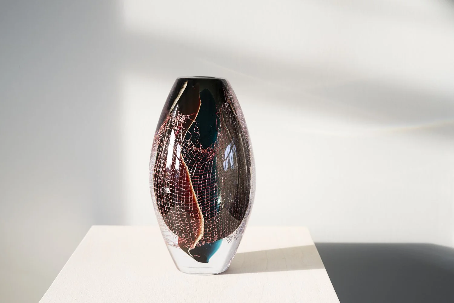 Crystal Clear #19 by Francisca Snel, a dark blown glass sculpture with copper mesh and deep red tones.
