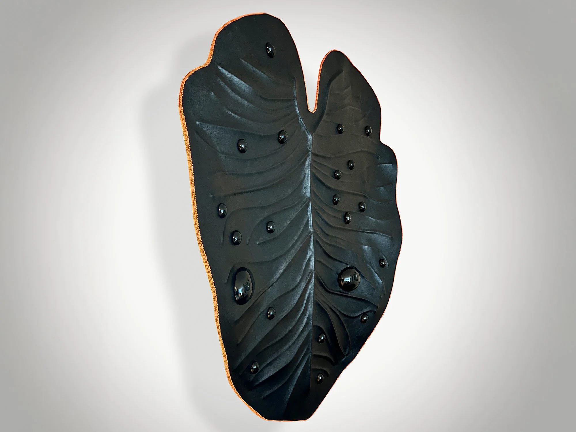 Sculptural leather artwork with tactile texture and reflective steel spheres, 120 x 100 cm