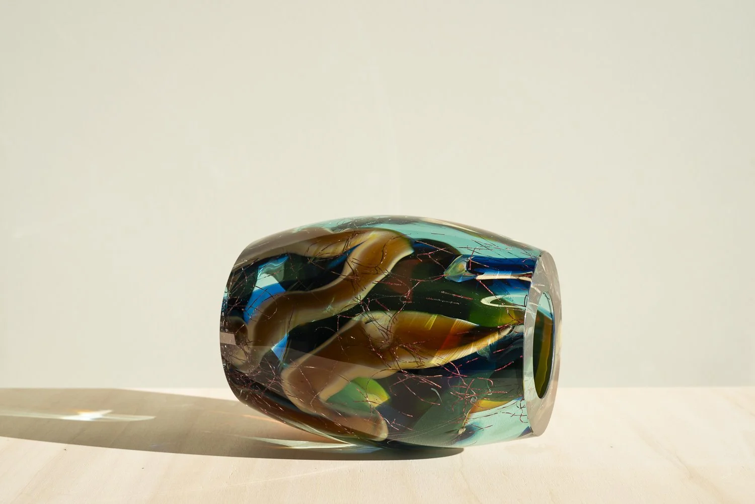 Stellar Magnitude 3 by Francisca Snel, a horizontal glass sculpture with curved blue, green and amber layers.