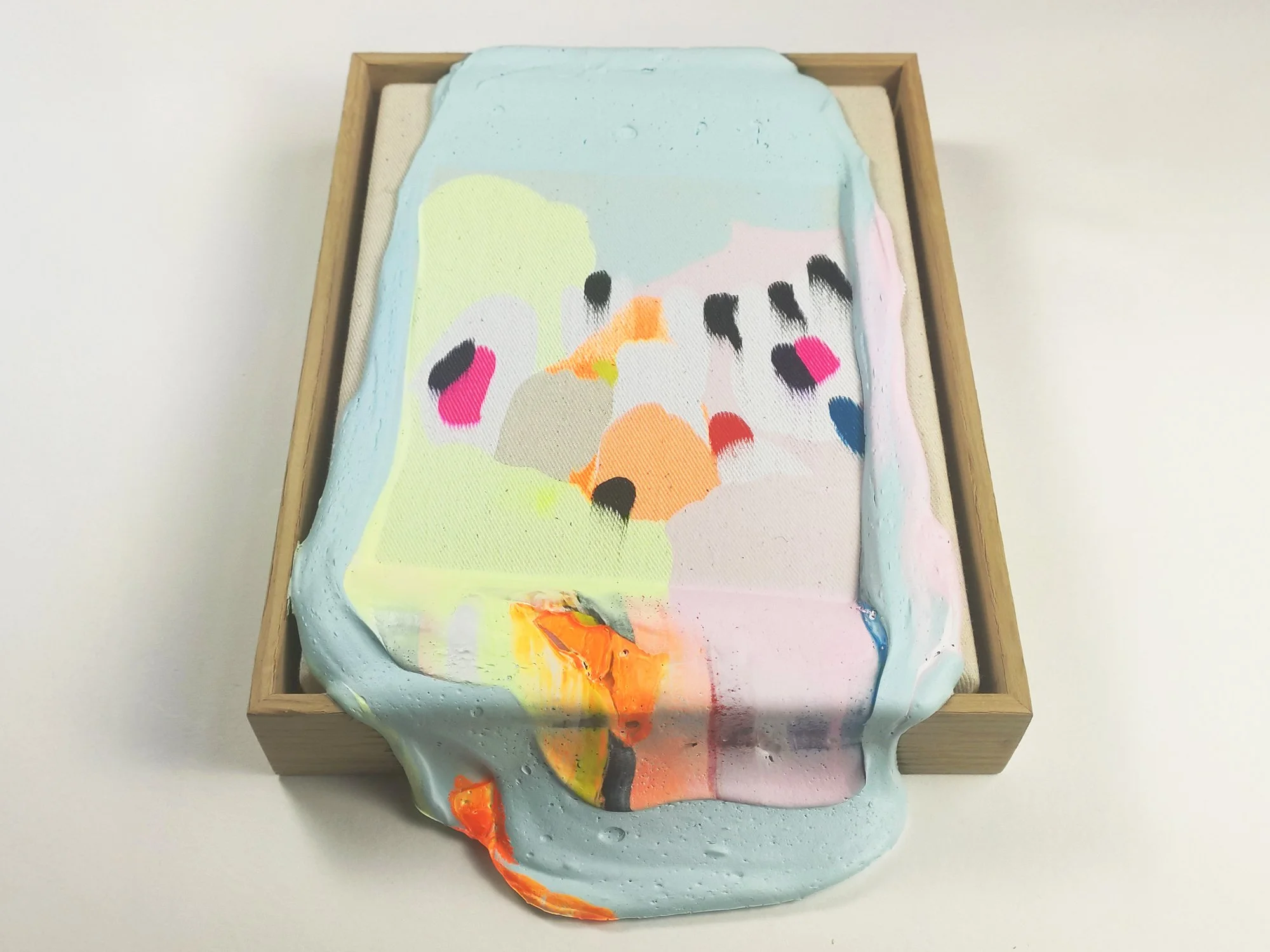 Detail of abstract mixed media artwork by Karen van de Vliet showing thick pastel blue paint layers, fluorescent orange accents and textured sculptural surface on canvas.