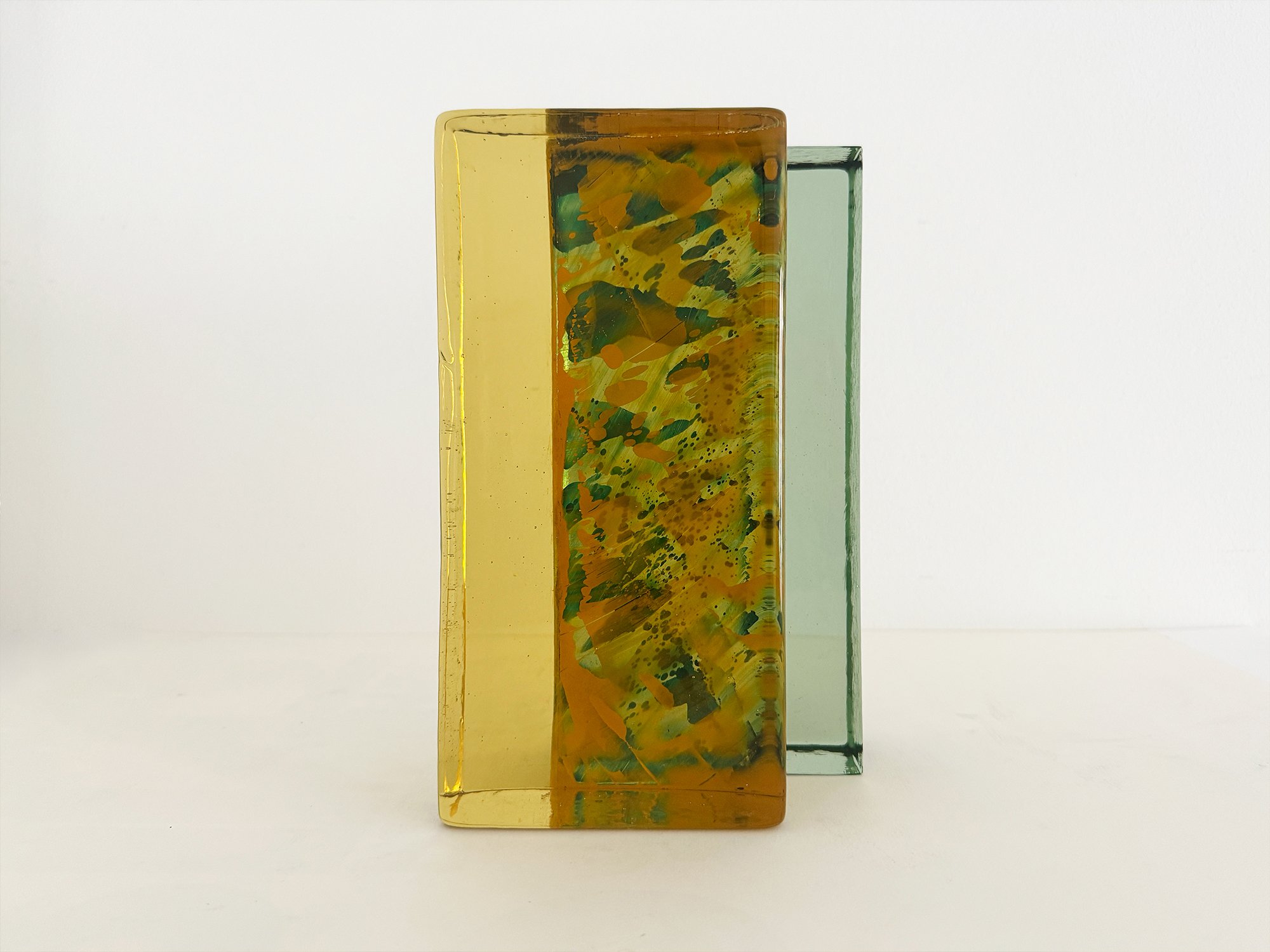 Green and amber glass sculpture Spatial Shade IX by Lisette Schumacher showing stacked glass brick forms and transparency