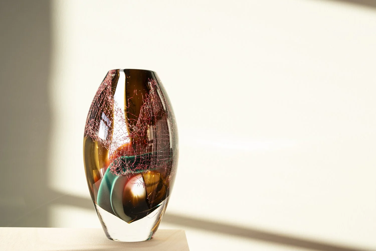 Alternative view of Crystal Clear #14 by Francisca Snel, showing the copper structure within the rounded glass body.