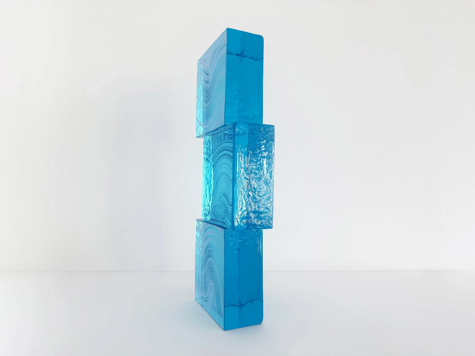 Side view of solid cast glass sculpture by Lisette Schumacher showing modular structure and optical depth