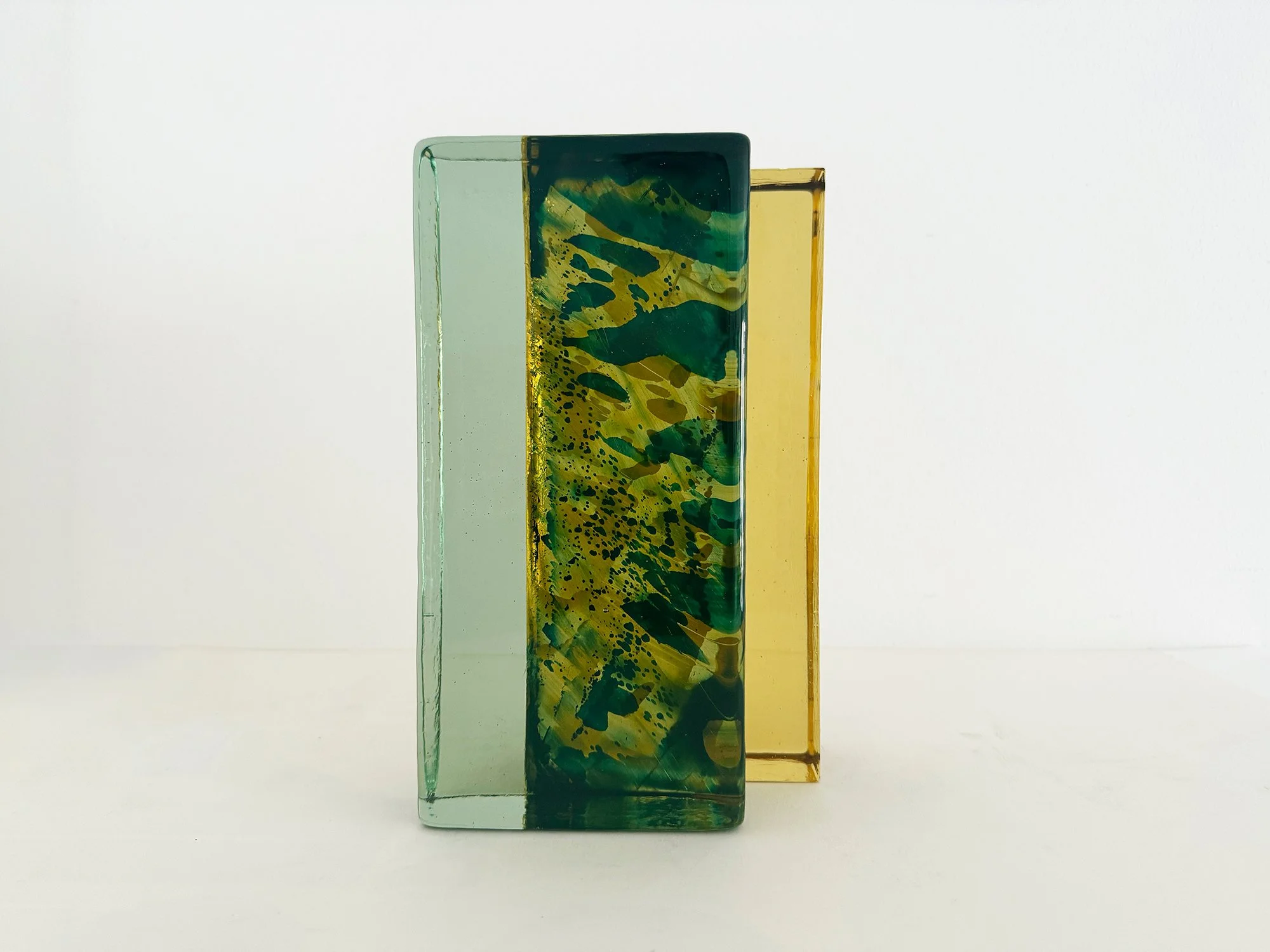 Handcast glass sculpture Spatial Shade IX by Lisette Schumacher in transparent green and amber coloured glass inspired by architectural brick forms