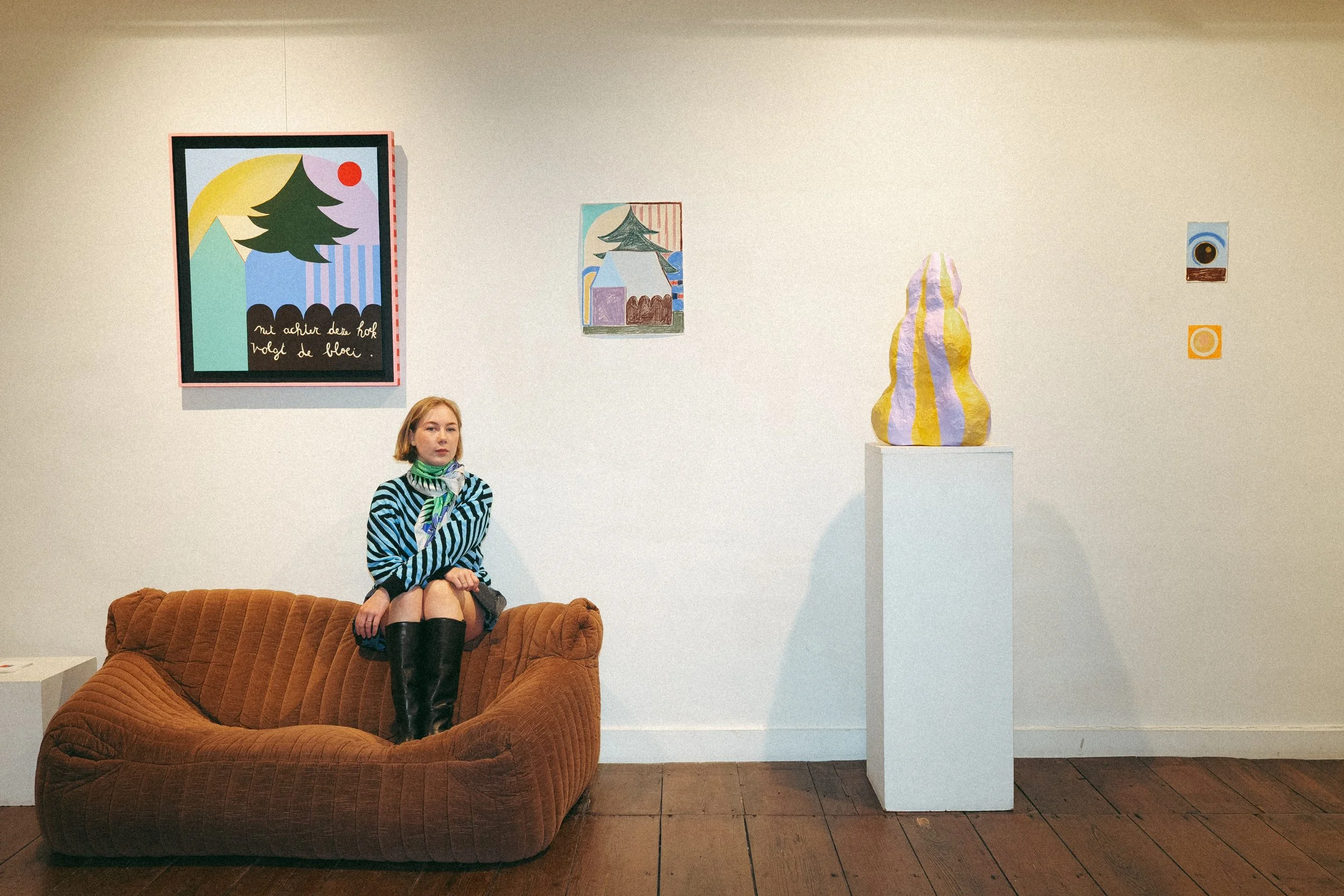 Emma Veulemans surrounded by her paintings, works on paper and a sculpture