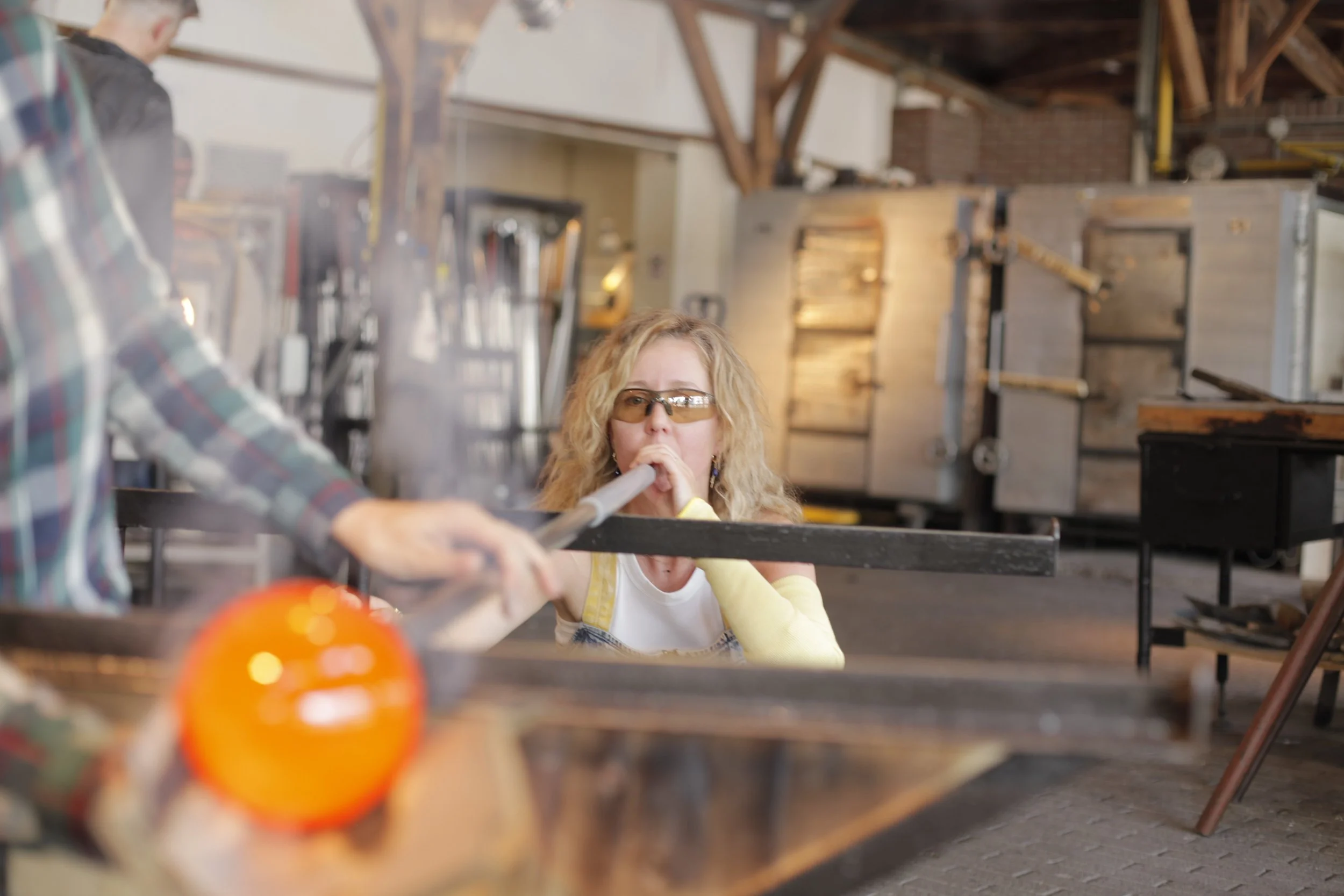 Artist Francisca Snel shaping molten glass during the glassblowing process for her contemporary glass sculptures.
