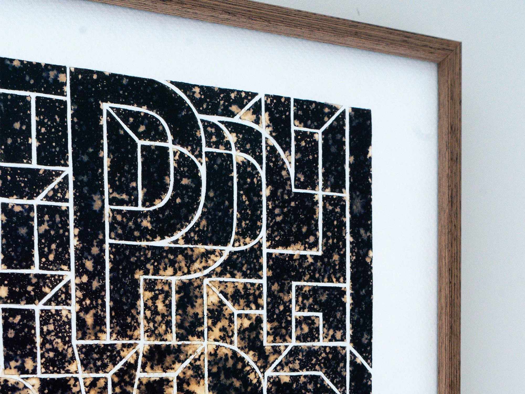 Detail of the upper letterforms in Saïd Kinos’s Ephemeral, framed by the work’s wooden edge.