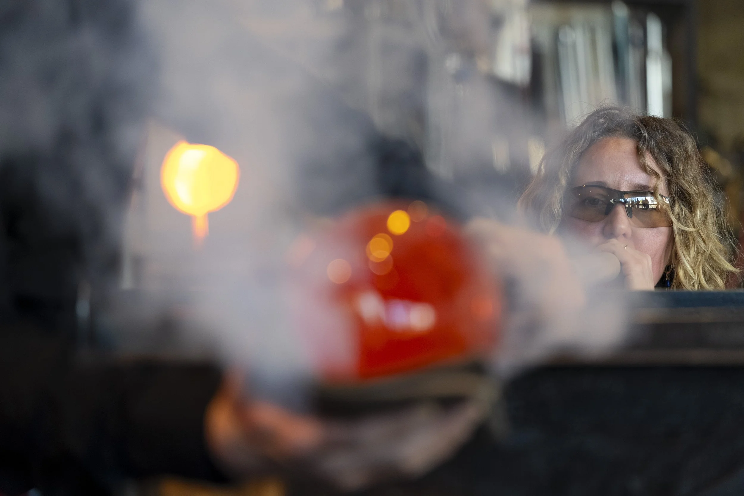 Francisca Snel working with molten glass in a professional glassblowing studio in the Netherlands.