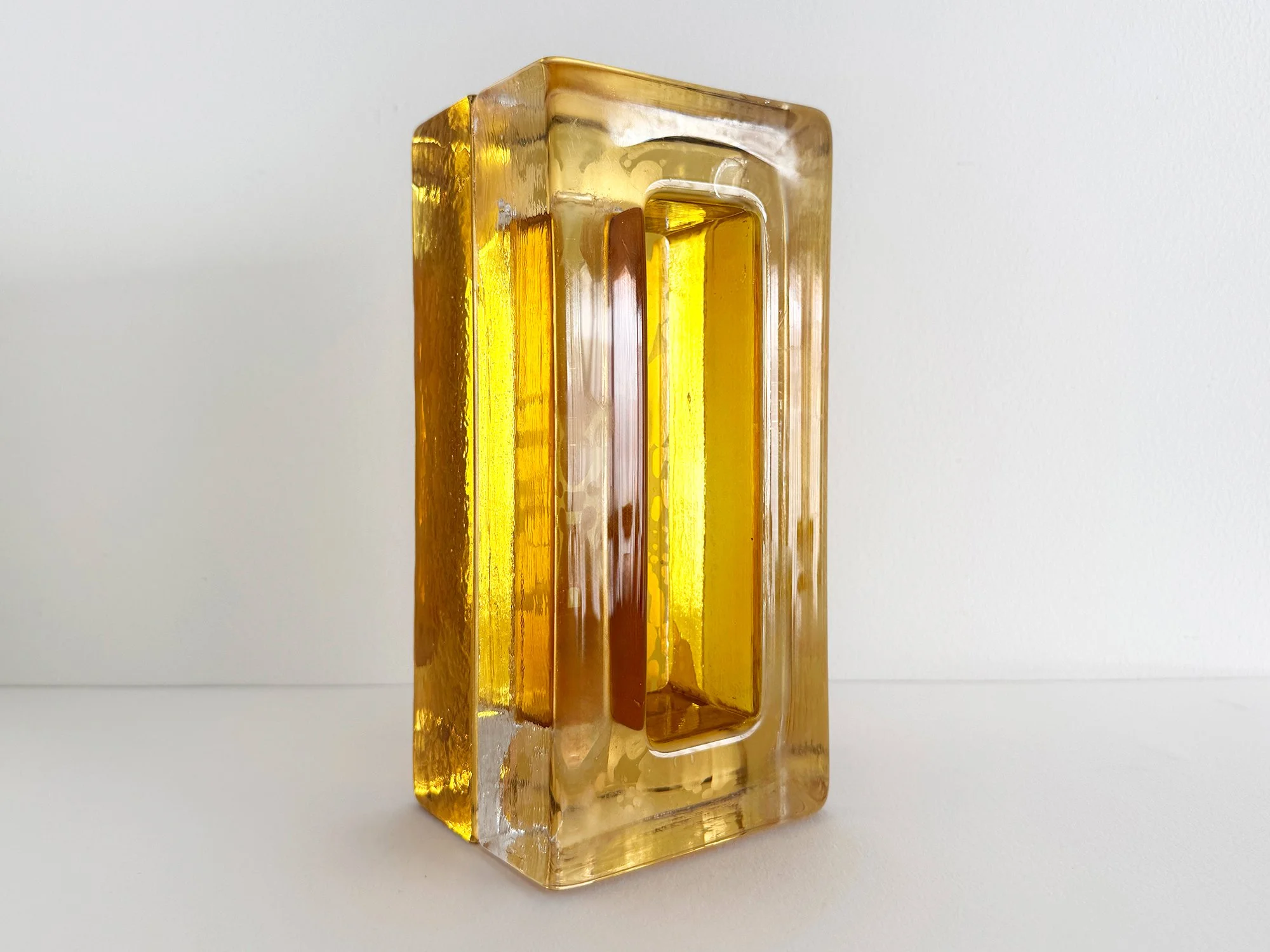 Lisette Schumacher solid cast glass sculpture with central void and amber translucent layers