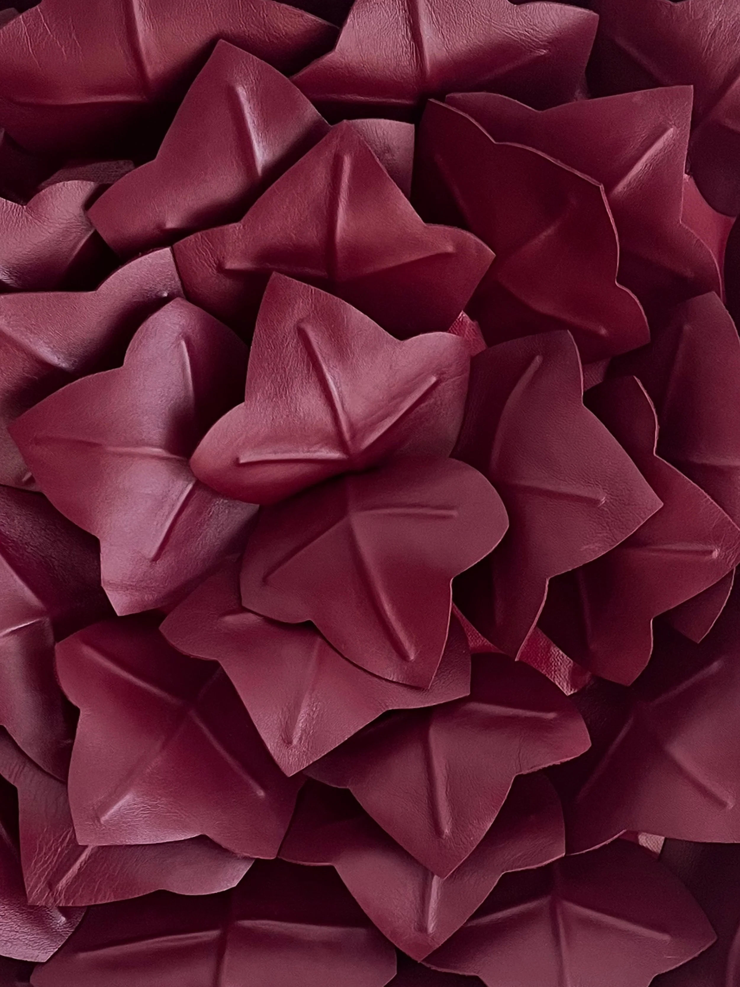 Detail of a red, leather sculpture by Madelon Uljee, showing organic folds and tension in the material