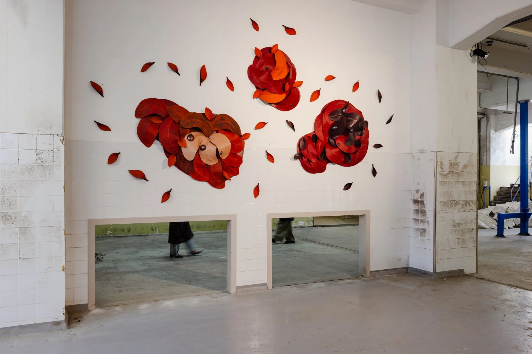 Angled installation view of After the Storm by Madelon Uljee, with burgundy and orange leather forms contrasting against the white walls.