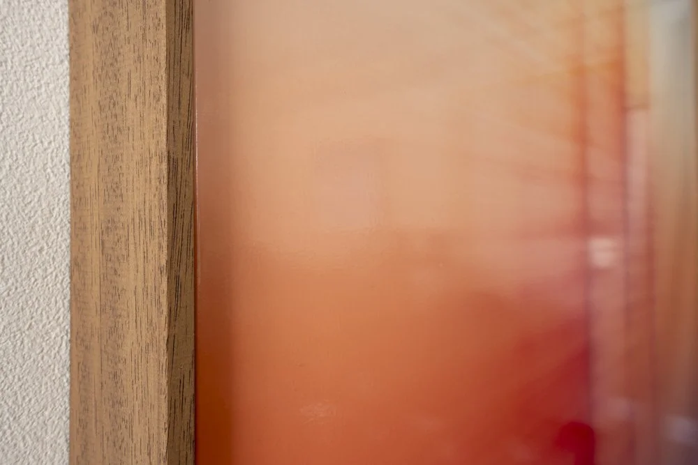 Framed abstract painting seen from an angle with vibrant colour surface