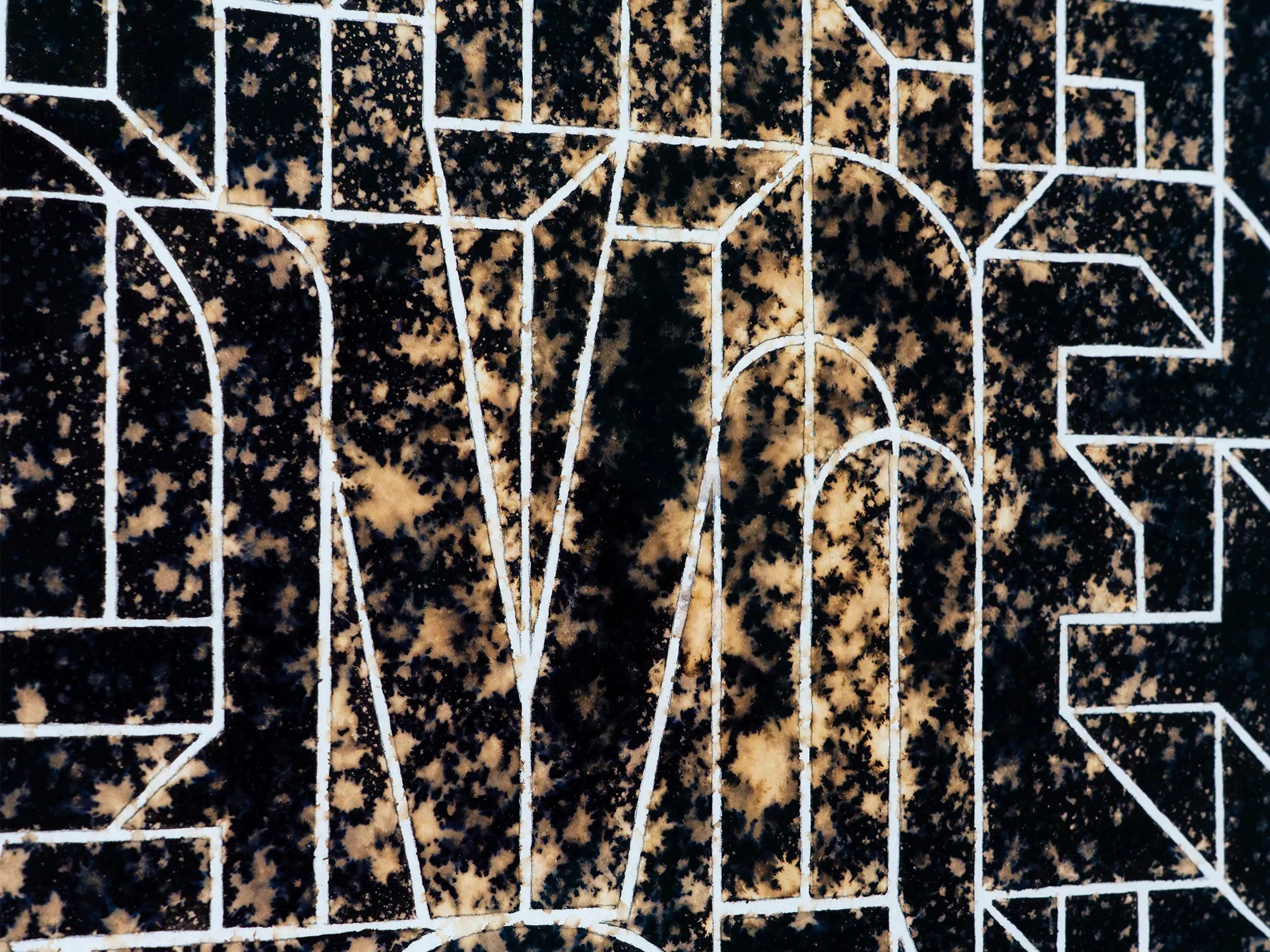 Close-up of Ephemeral, showing white outlined letters against the mottled black and ochre surface.