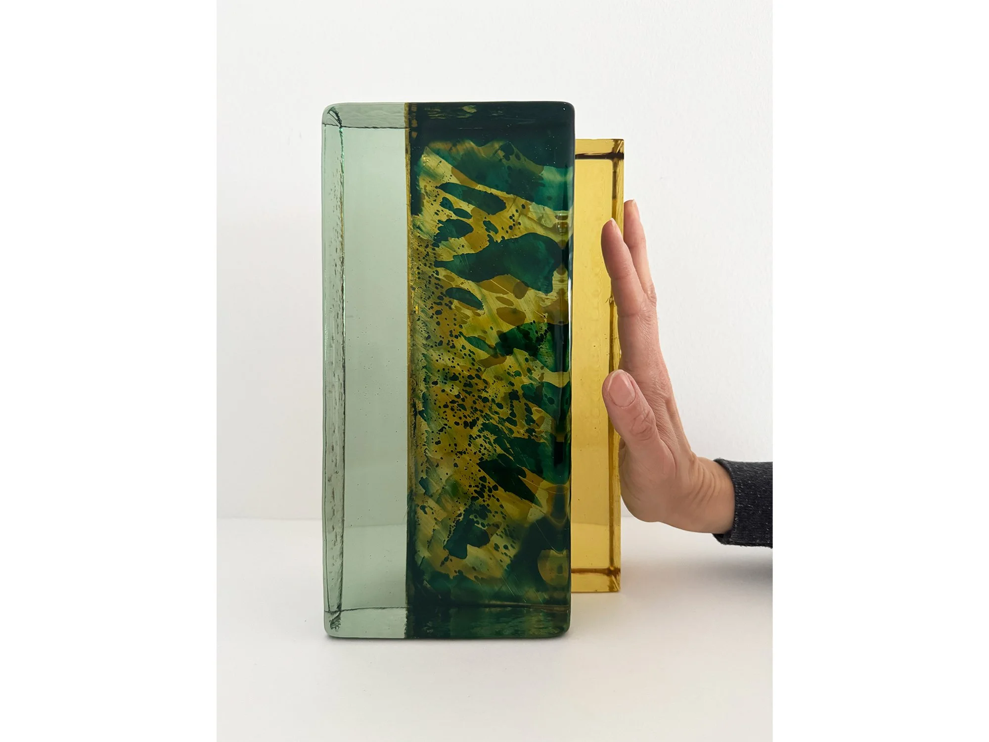 Hand holding Spatial Shade IX glass sculpture by Lisette Schumacher showing scale of the solid handcast coloured glass object