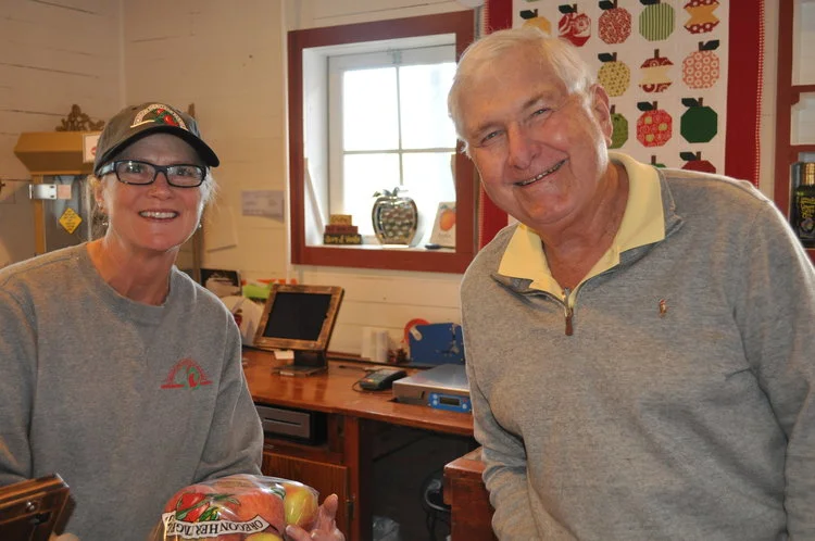Kim helps a loyal customer get his apples for the week