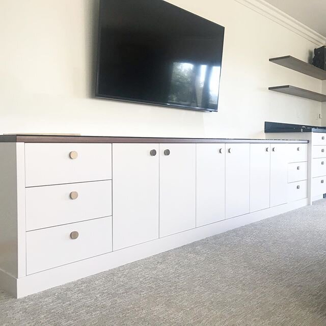 Finally hung hardware on this project from last year! The Knobs they wanted were super back ordered and so we waited!  Family room cabinetry. White CV with solid walnut floating shelves and counter top. Brass knobs. The wet bar has black marble with 