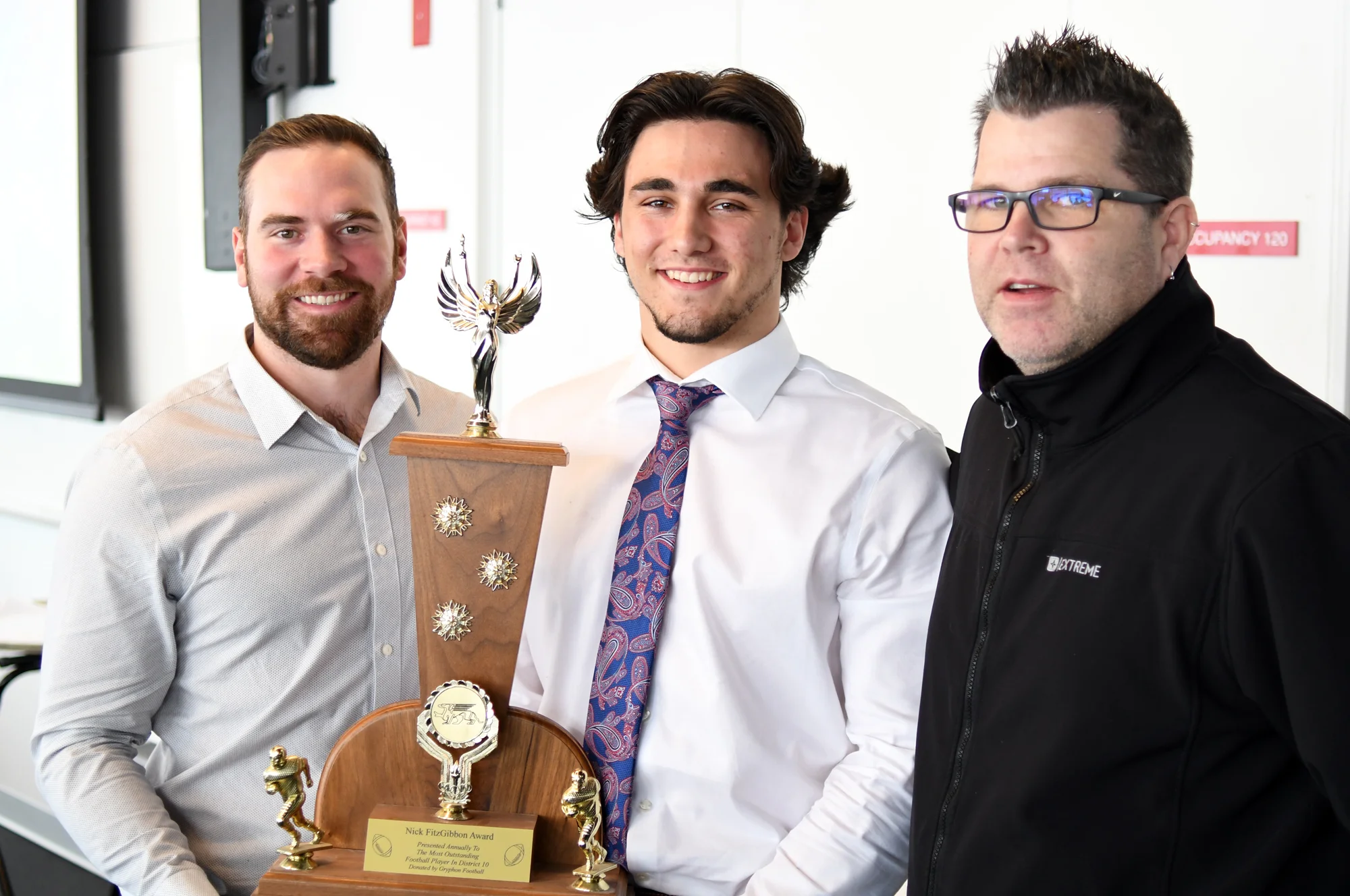 Former Gryphon great Nick FitzGibbon, left, with the winner of the Fitzy as most outstanding player in D10 football Tanner Nelmes, middle, and St. James coach Jeff Cummings.