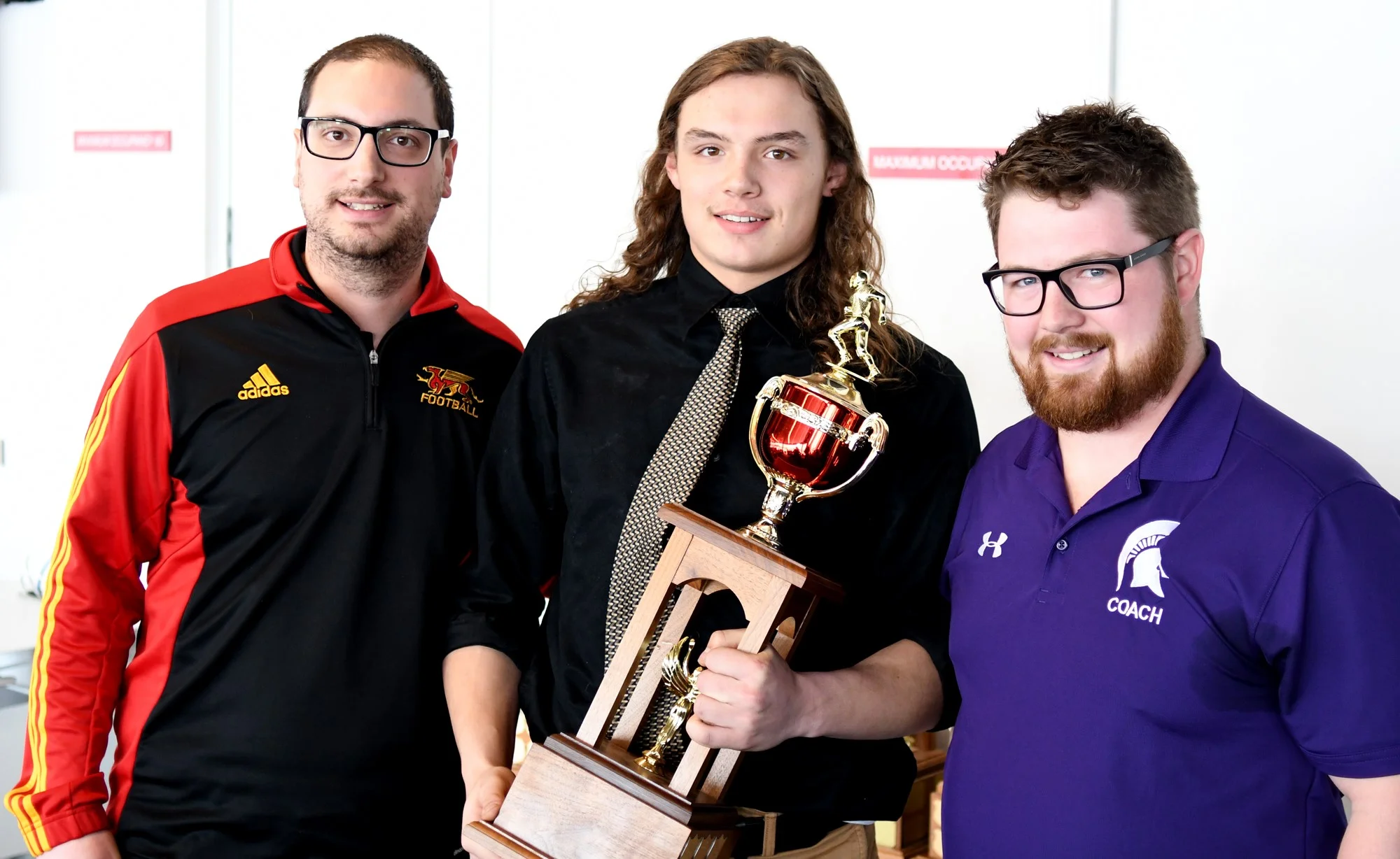 Gryphon Director of Football Operations Mike Aloisio, left, with offensive player of the year award winner Daniel Brown, middle, and Centennial coach Chas Douglas.