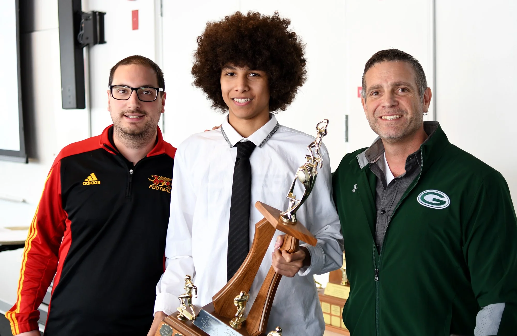 Gryphon Director of Football Operations Mike Aloisio, left, with rookie of the year award winner Keyon Robinson, middle, and Guelph CVI coach Dan Crabbe.