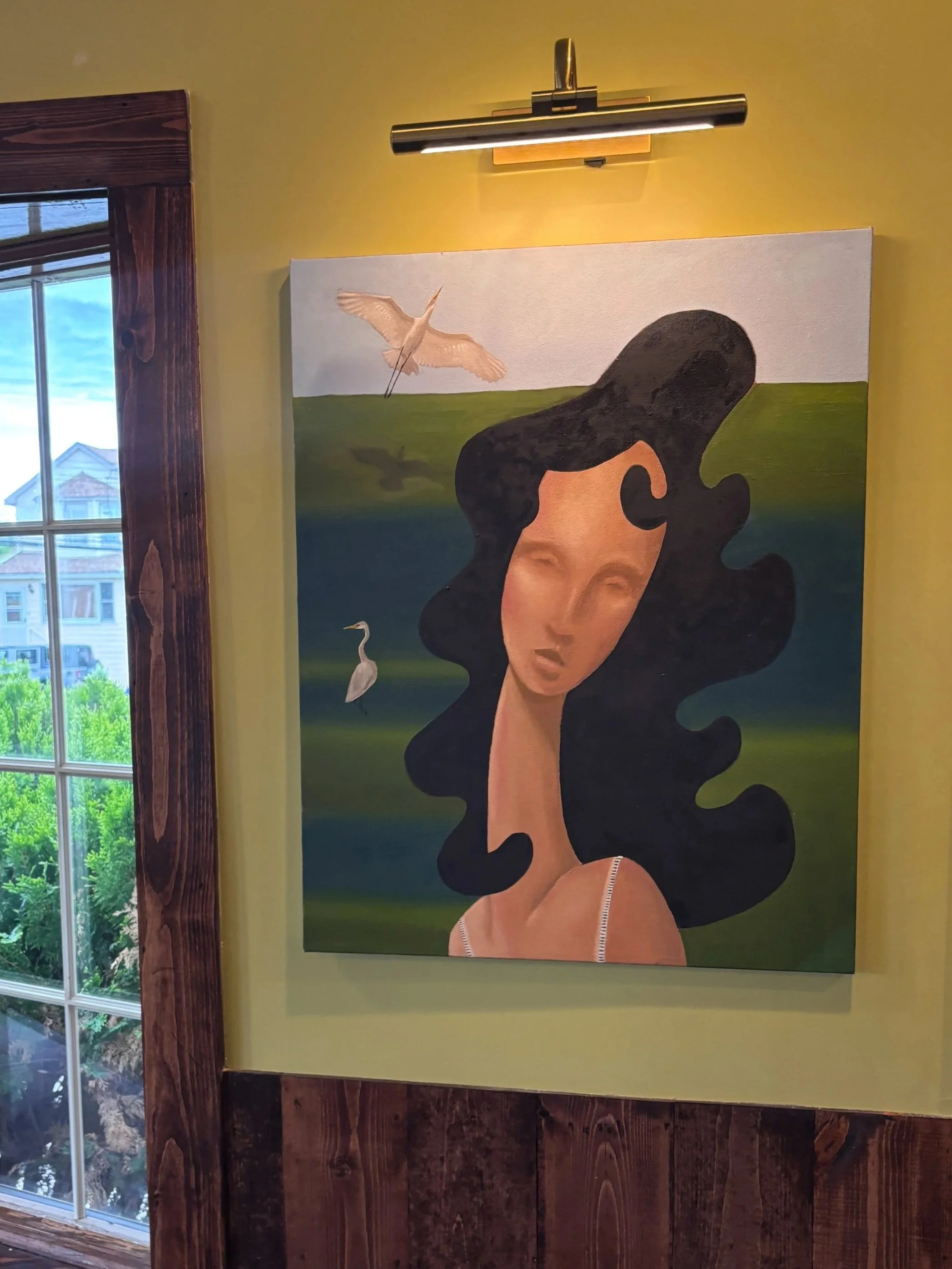 Painting of a woman with black curly hair and closed eyes, wearing a white top, with a landscape background featuring a heron flying and a green hill.