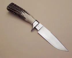I forged this knife from 1095 tool steel.It has a differential heat treat causing a striking hamon. The 5" clip-point blade has a full flat grind with a convex edge, hand rubbed to 1200 grit. The guard and buttcap are 416 stainless with copper spacers and the handle is Sambar stag. This knife won Best Hand Forge Knife at the 2005 MKA Knife Show!!