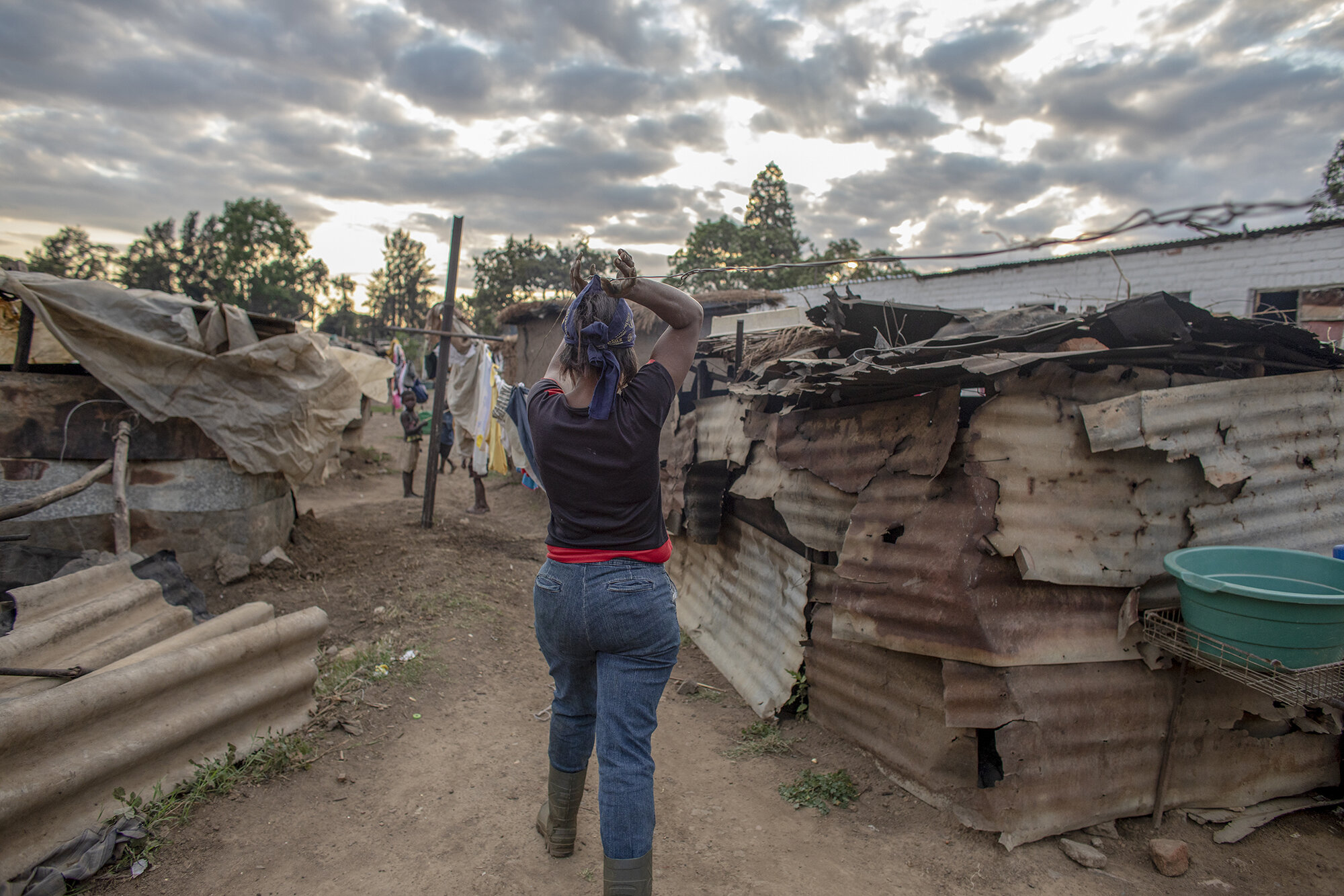 October 21, 2018: Roselyn walks back to work from her home on the farm compound after checking on her children during her dinner break. 