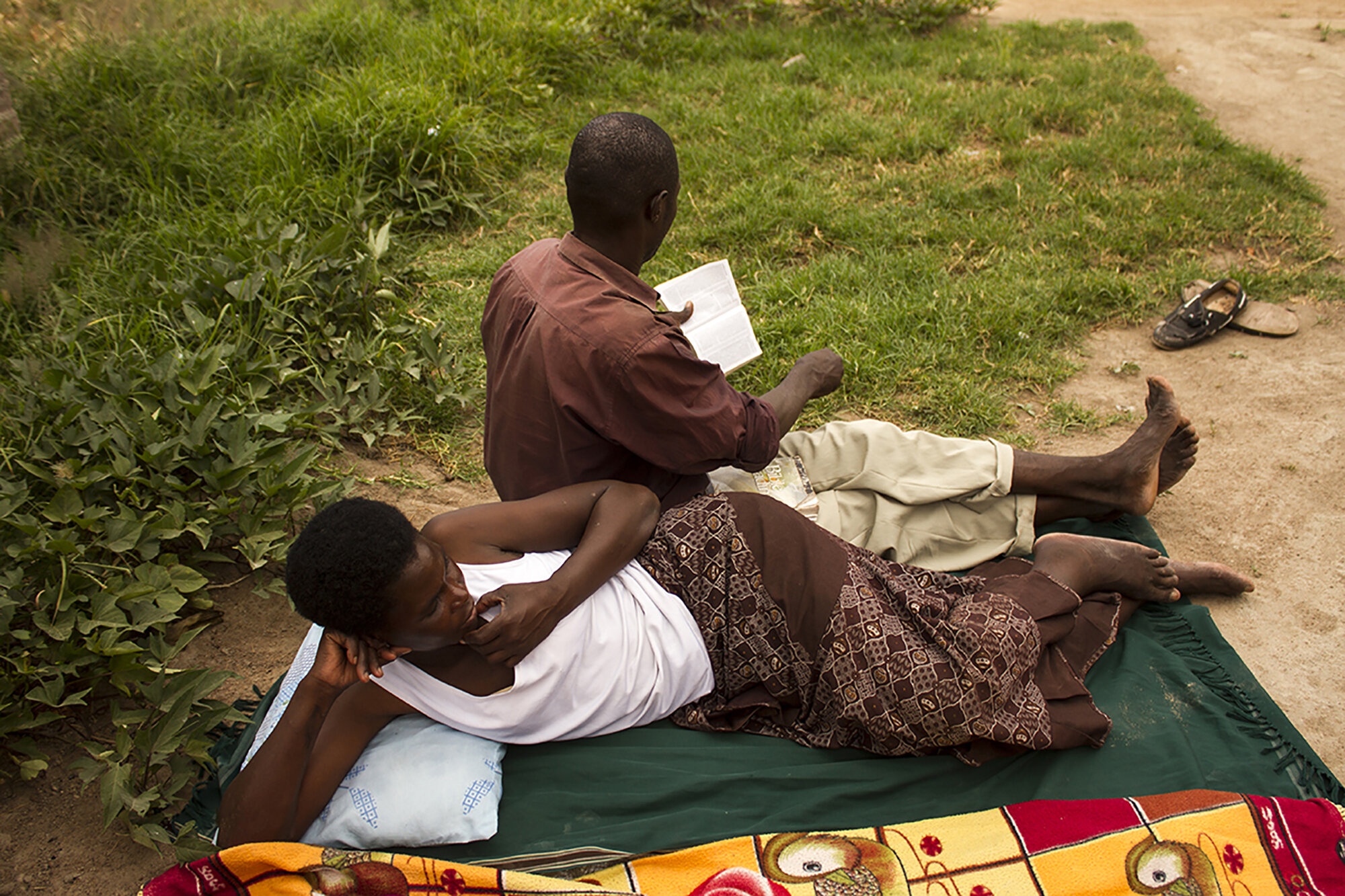 March 28, 2015: Duduzile and Morgan, her partner, relax while reading the Bible at their home on a Sabbath in Hopely Zone 6, Harare. She was raised a Seventh Day Adventist. 