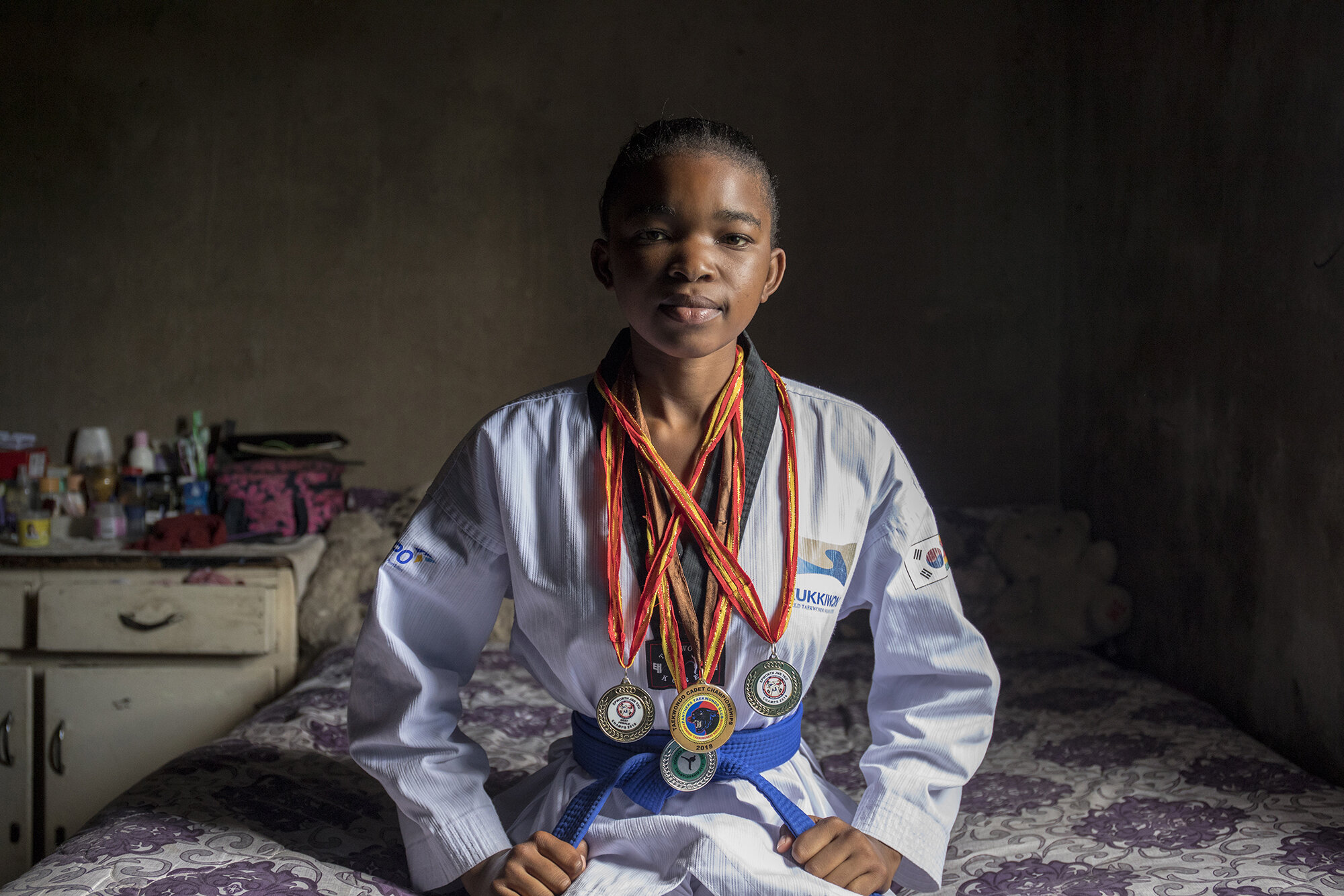  Natsiraishe Maritsa sits in her room for a portrait at her family home in Epworth, Zimbabwe. Natsiraishe uses taekwondo sessions to teach and empower young girls and teen mothers in her community to prevent early child marriages. About 34 percent of