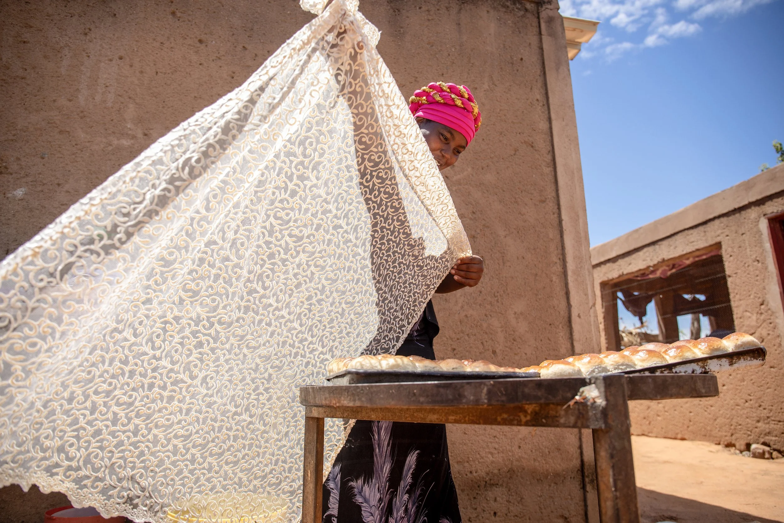  Nkele Dube covers a fresh batch of tea buns in Ward 22, Bulilima, Zimbabwe. -  For Help Germany  