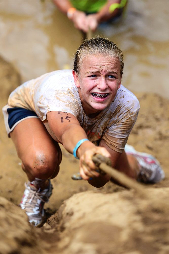 A participant climbs a muddy cliff above Drakes Creek in the Bowling Green Gauntlet Mud Run at Phil Moore Park. | July 12, 2014 | Alvaton, Ky.